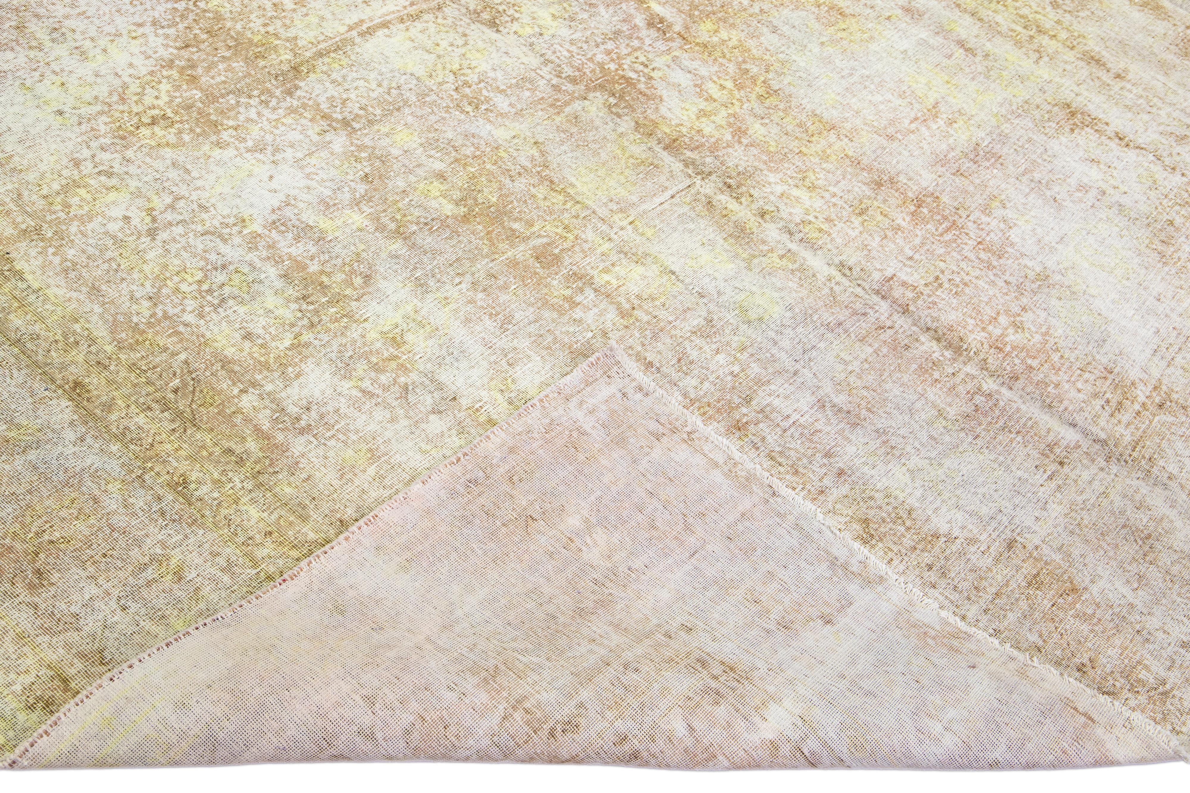 Beautiful vintage overdyed hand-knotted wool rug with a tan field. This overdyed rug has yellow and white accents in an all-over design.

This rug measures: 9'3'' x 11'9