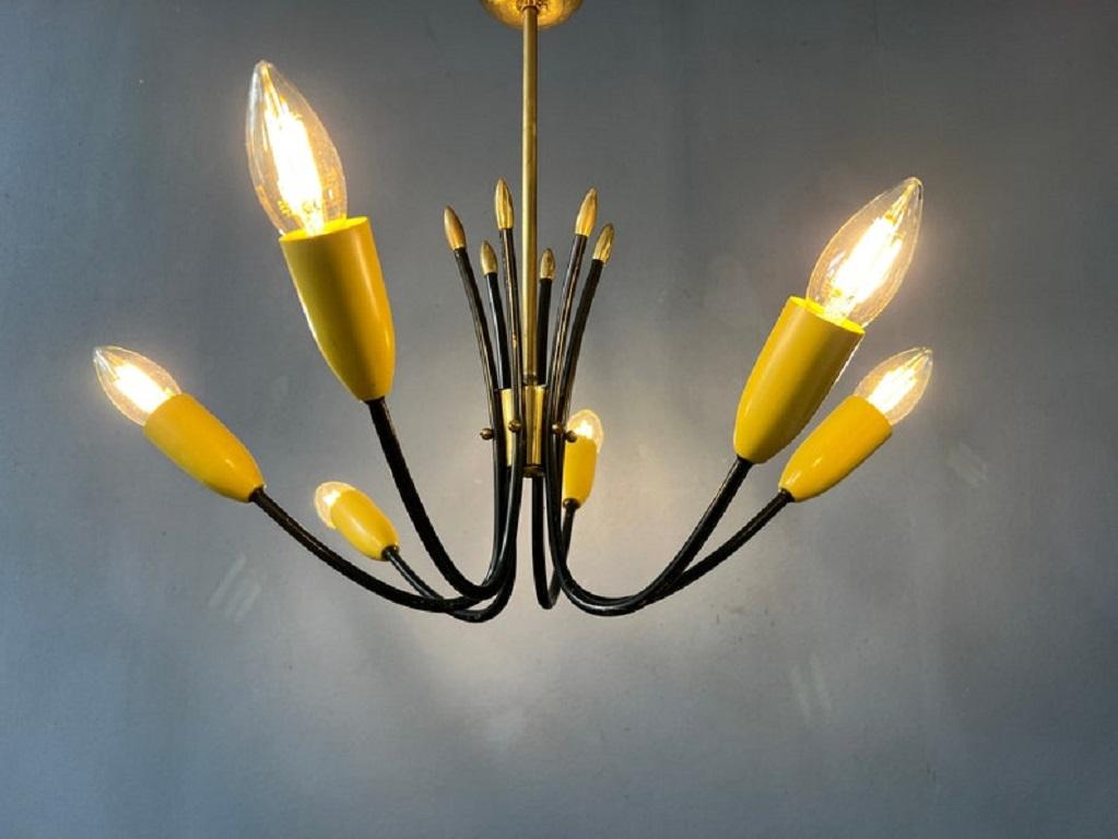 Classica lampada a ragno vintage degli anni '50. La lampada ha sei luci gialle. La cornice nera si combina bene con gli elementi gialli e oro. La lampada richiede tre lampadine E14 (di forma ovale).

Informazioni aggiuntive:
Materiali:  Metallo,