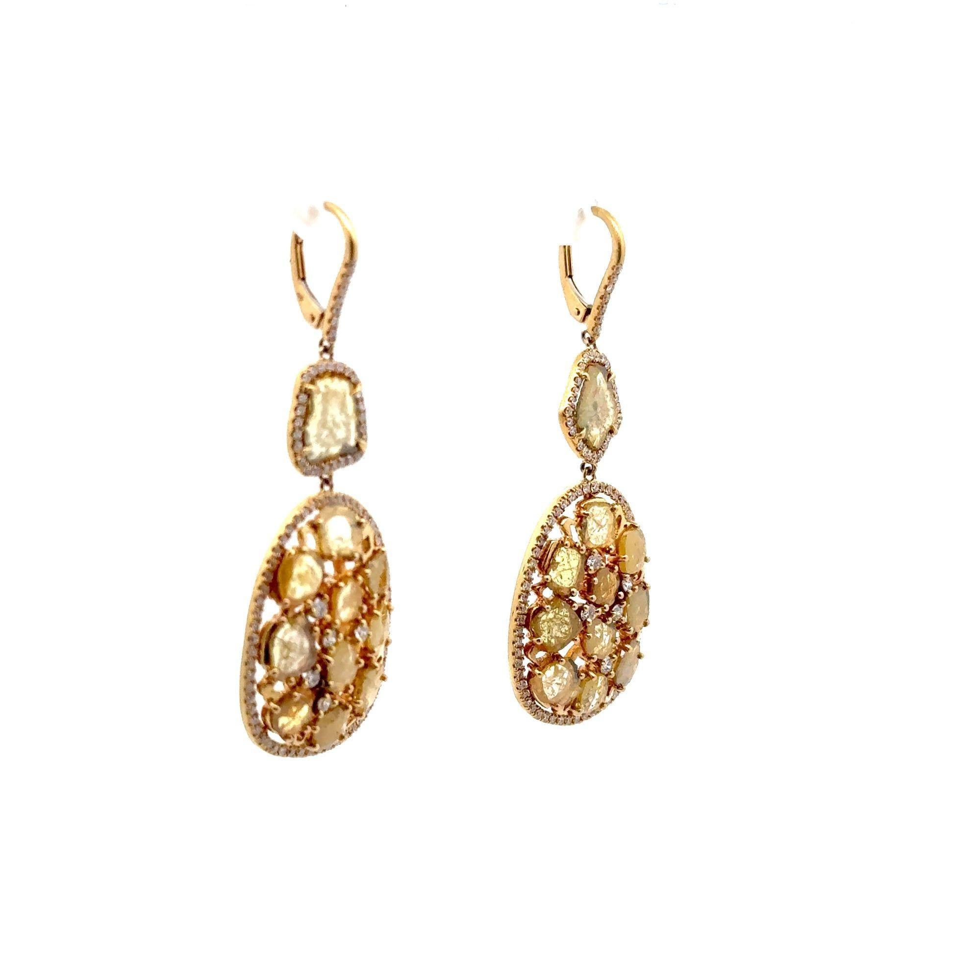 A magnificent crafted pair of drop earrings, featuring irregular shapes of yellow diamond slices. Each diamond slice reflects the warm hues of the 18kt yellow gold, adding a touch of luxury and sophistication to your ensemble. The dainty dangle