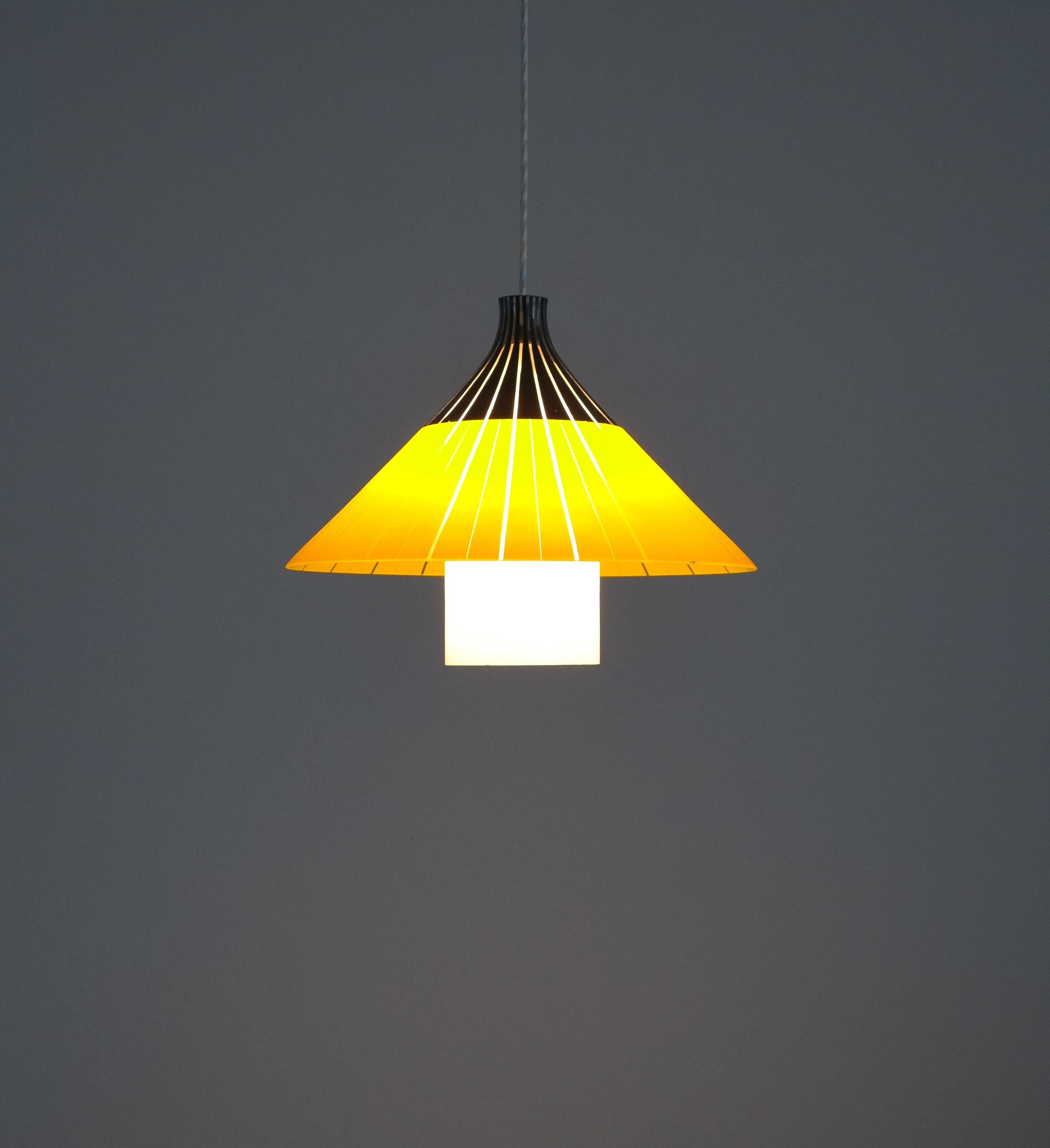 Yellow white glass pendant lamp glass, Italy, circa 1950

Beautiful Italian pendant light shaped like an Asian rice hat, the conical hat is fully made from yellow, black glass with clear glass stripes. The tubular diffuser is made from opal glass.