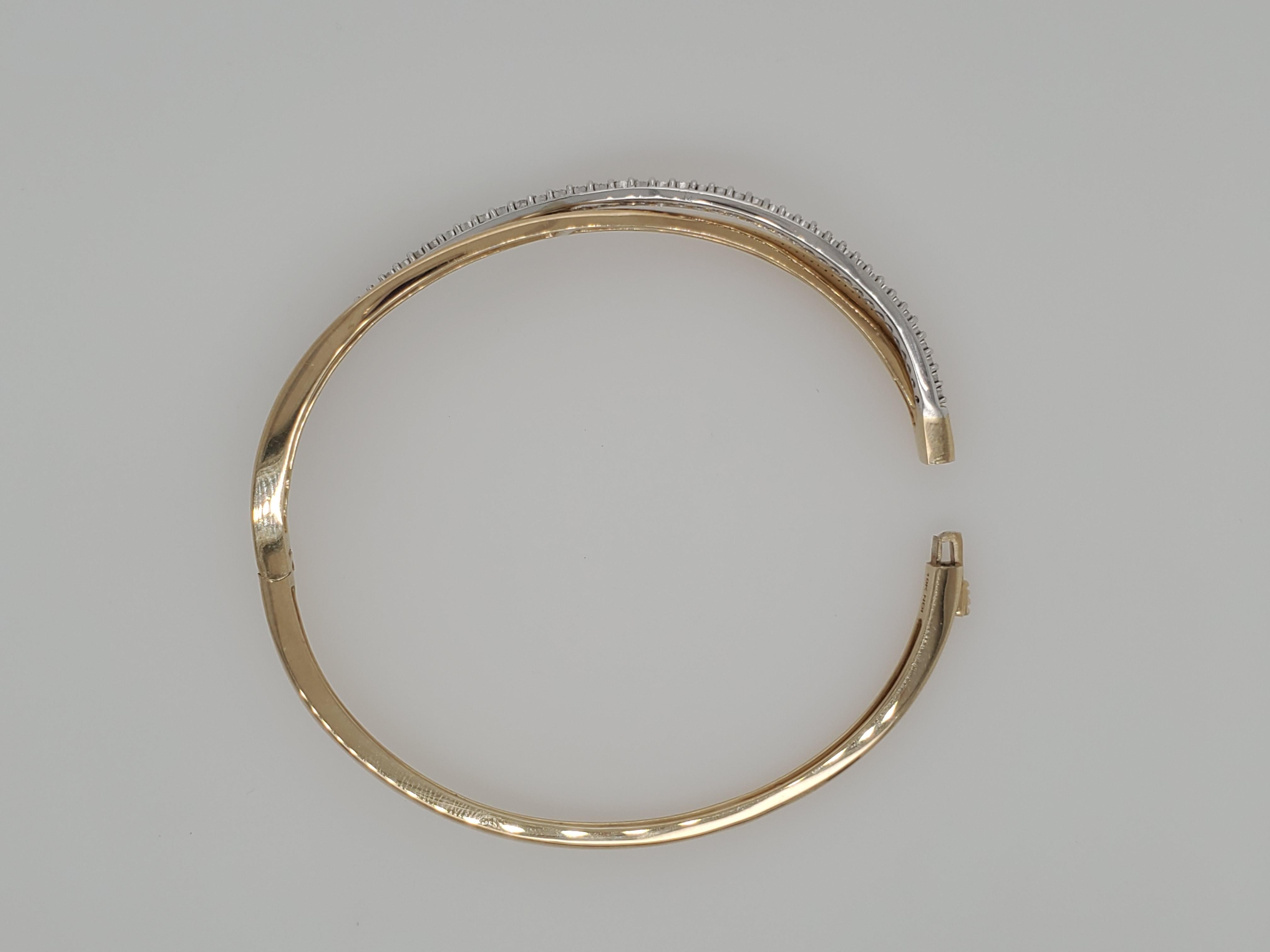 Beautiful 10 karat yellow & white gold round diamond bypass bangle bracelet. The diamonds have a total weight of 1/3 carat & are HIJ/I1-I2 in quality. The bracelet is hinged with a push button clasp. It will fit most wrists, average sized. Weighing