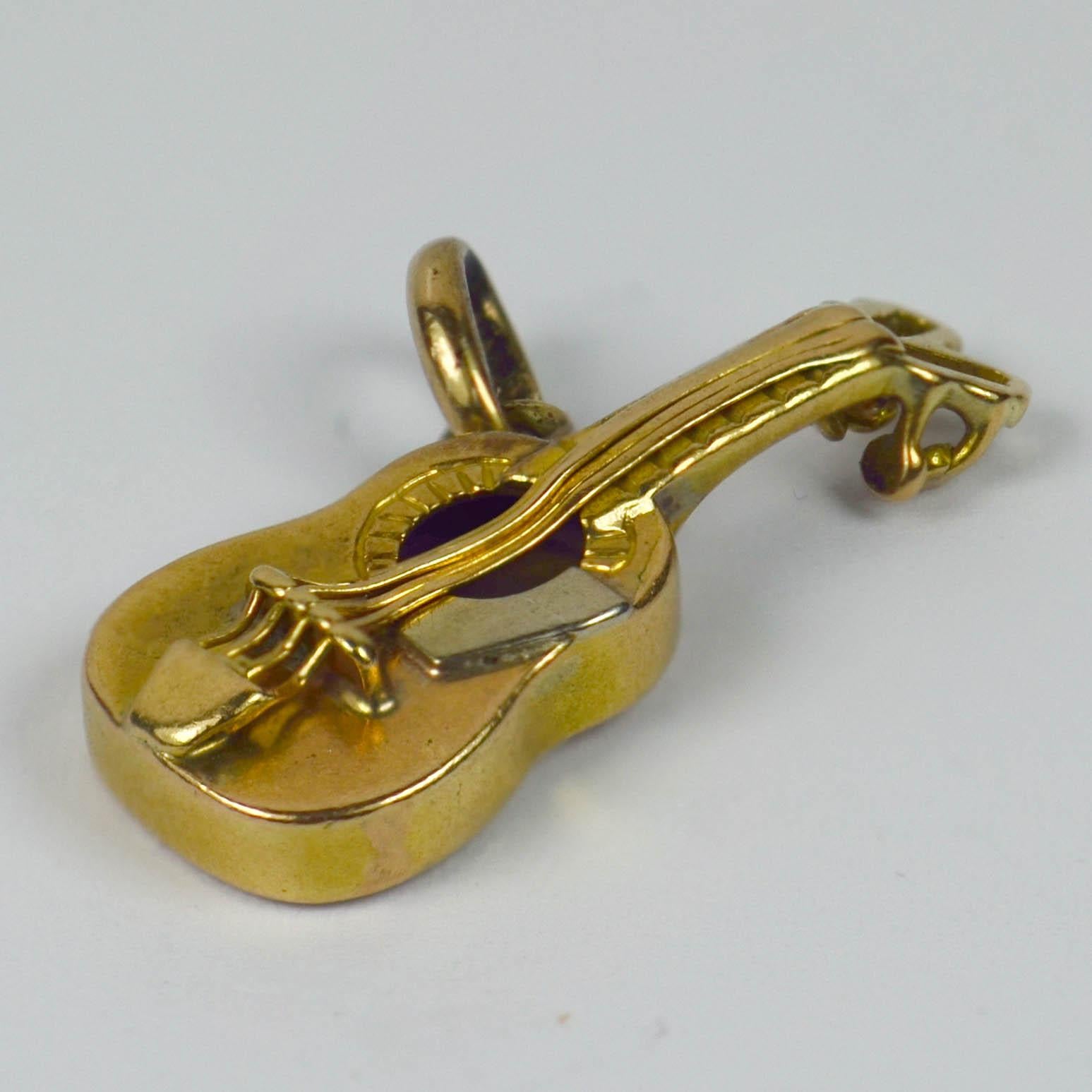 An 18 karat yellow and white gold charm pendant designed as a guitar. Stamped with French import marks for 18 karat gold.

Measurements: 2 x 1.2 x 0.3 cm
Weight: 1.31 grams