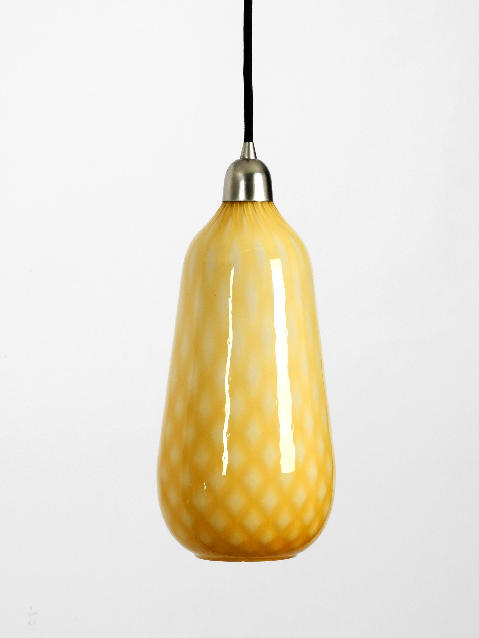 Beautiful yellow and white Italian midcentury Murano glass pendant lamp
in rare design with a checked pattern. Fantastically beautiful and very noble design
in a very good vintage condition. Lampshade is made of Muarnoglas inside white.
Made in