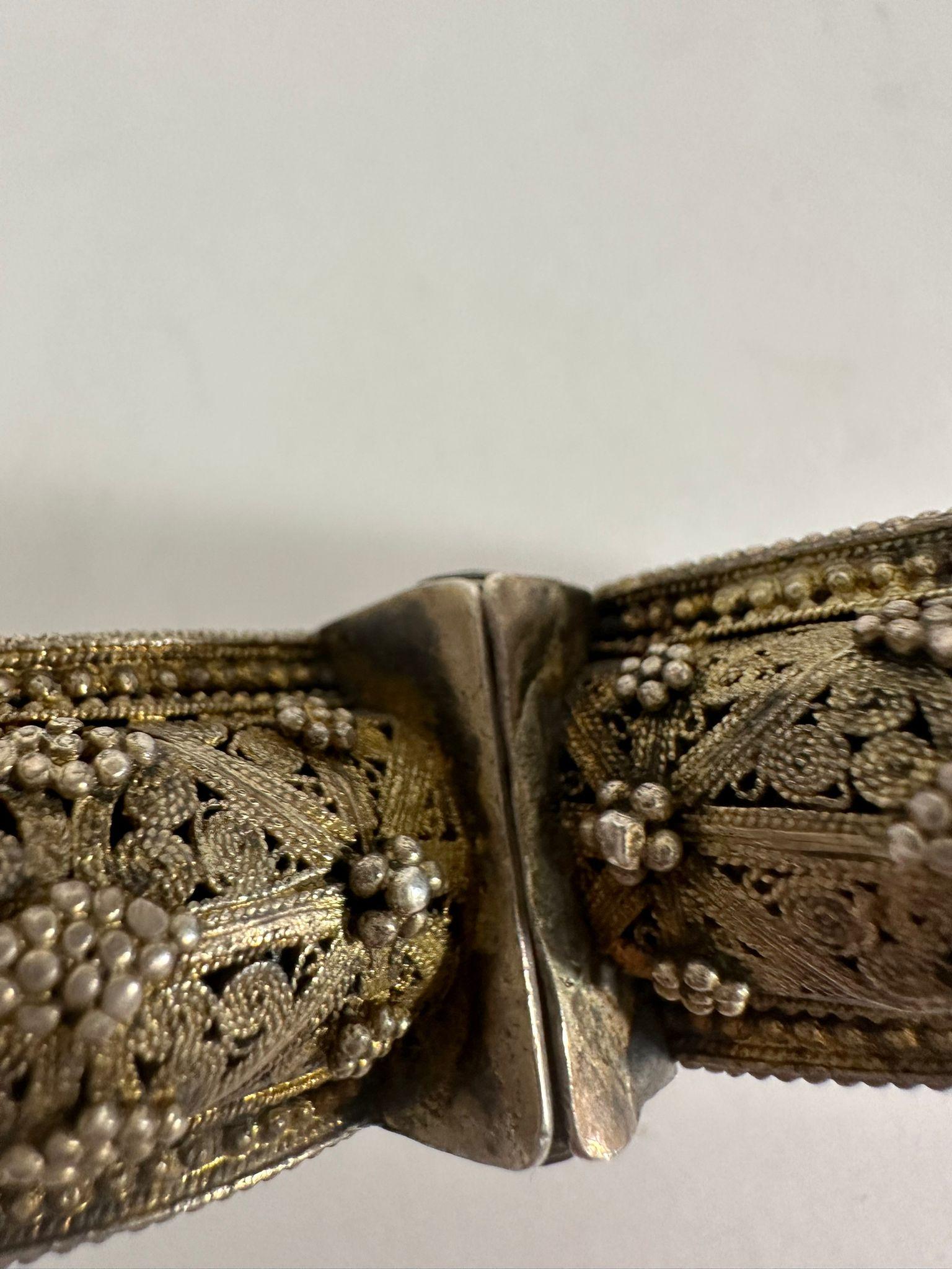 Questo squisito braccialetto d'argento fatto a mano è un notevole esempio di gioielleria da sposa tradizionale ebraica yemenita, realizzata come parte di un set di dote. Realizzato meticolosamente con la distintiva tecnica della filigrana,