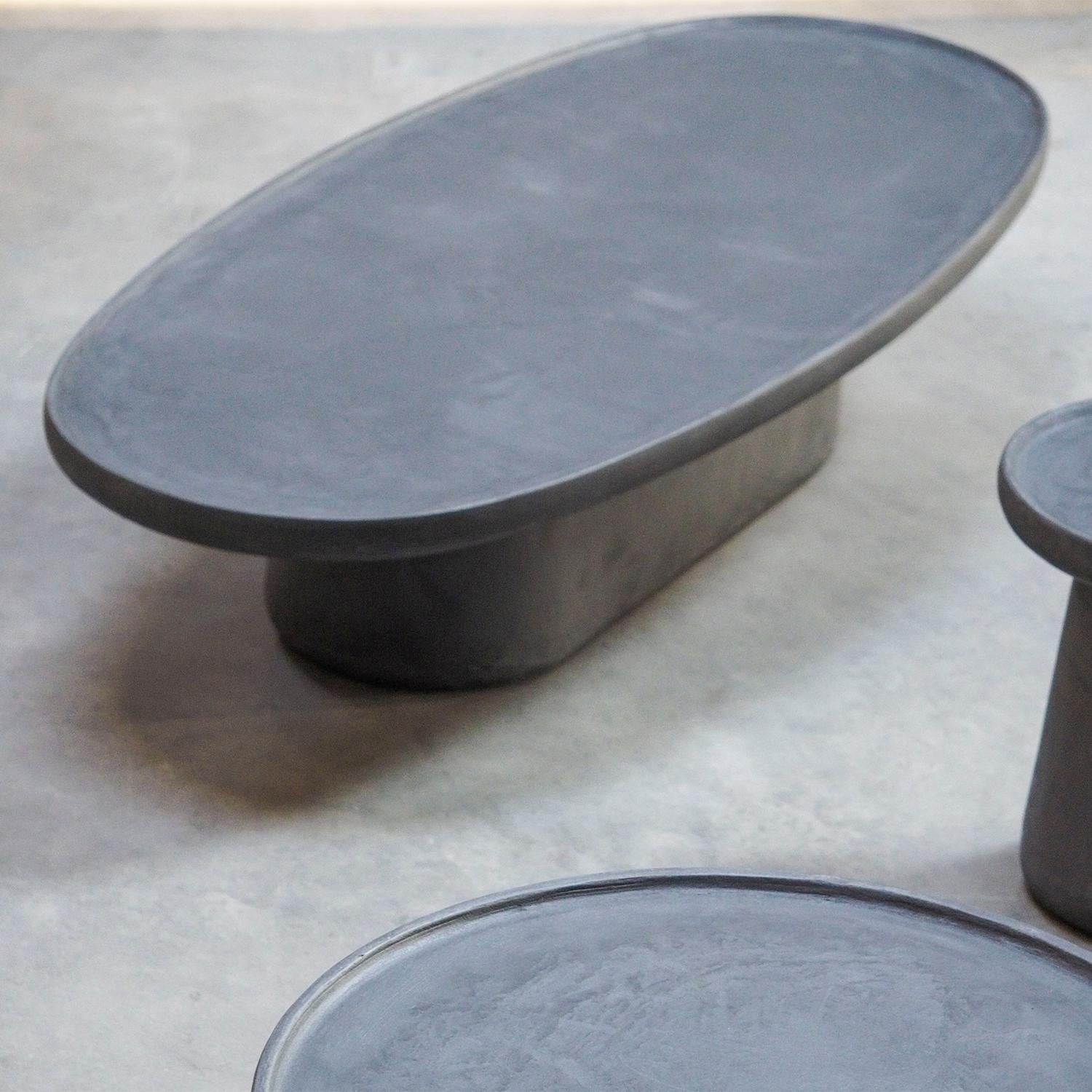 Table basse Yeshi Oval avec toute la structure en 
pierre calcaire fabriquée à la main en finition gris anthracite foncé.
Également disponible sur demande en finition extérieure, moyennant un supplément de prix.