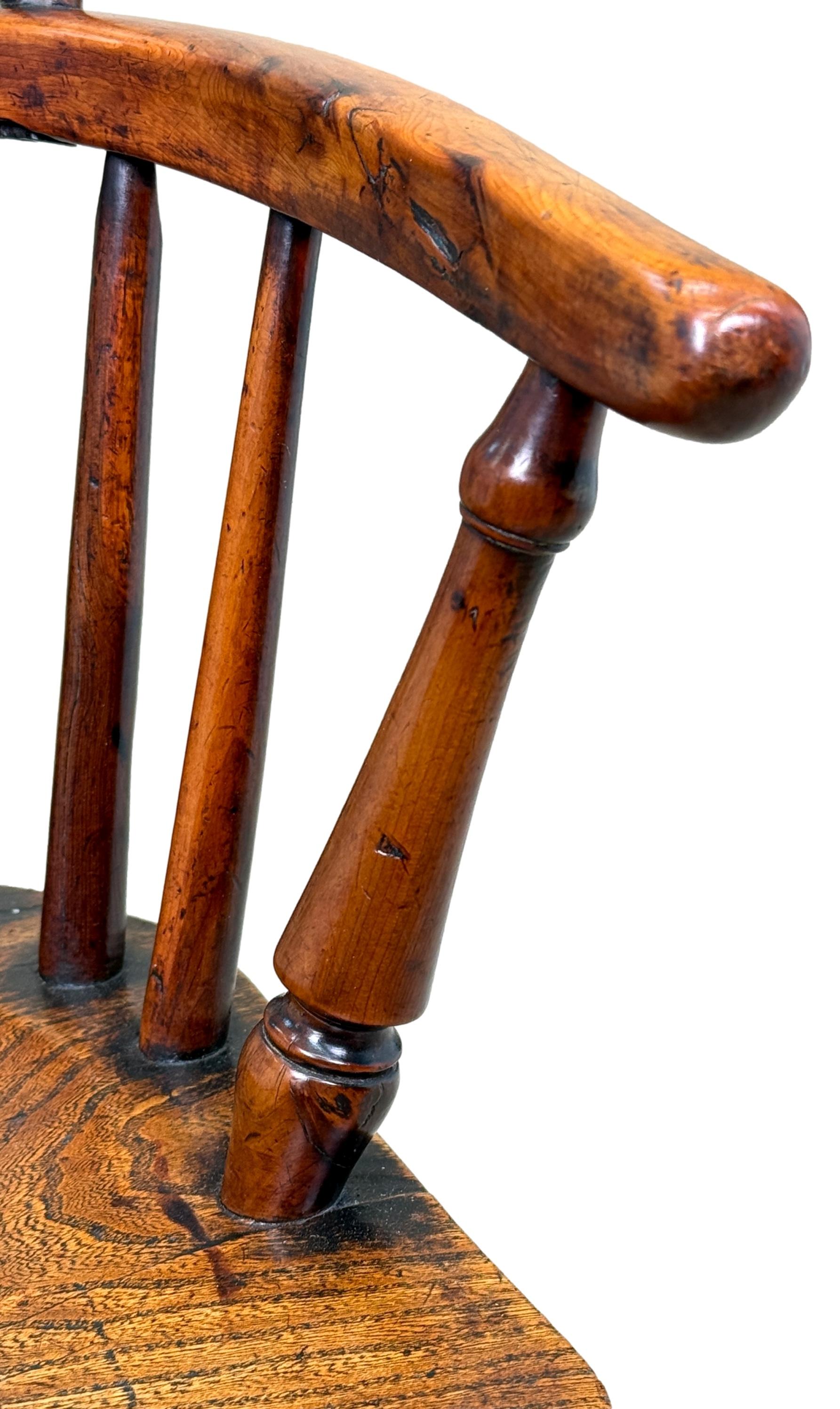 Fauteuil Windsor pour enfant du début du XIXe siècle en bois d'if, de frêne et d'orme, de très bonne qualité et extrêmement charmant, doté d'un élégant dossier en forme de houppe avec éclisse centrale percée et façonnée, flanqué de supports