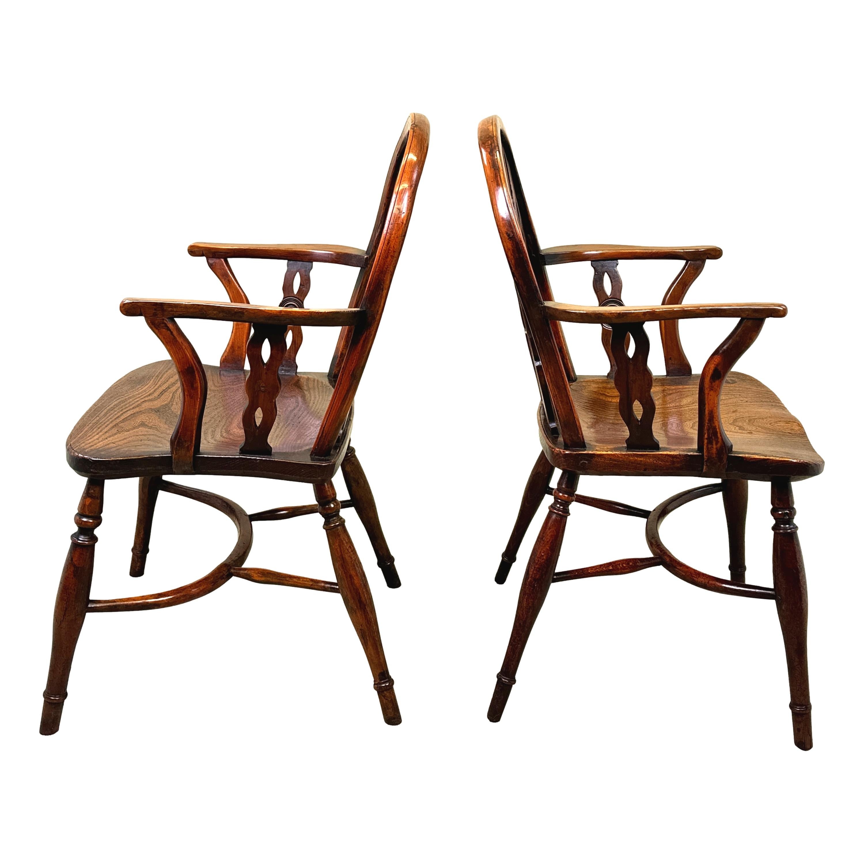 Eine charmante fast übereinstimmende Paar des frühen 19. Jahrhunderts, Georgian, Eibenholz, Low Back Windsor Sessel mit drei durchbohrt und geformt Splats mit zentralen Satz Roundels, oder Draughts, abwechselnd mit gedrehten Spindeln zu Rücken, über