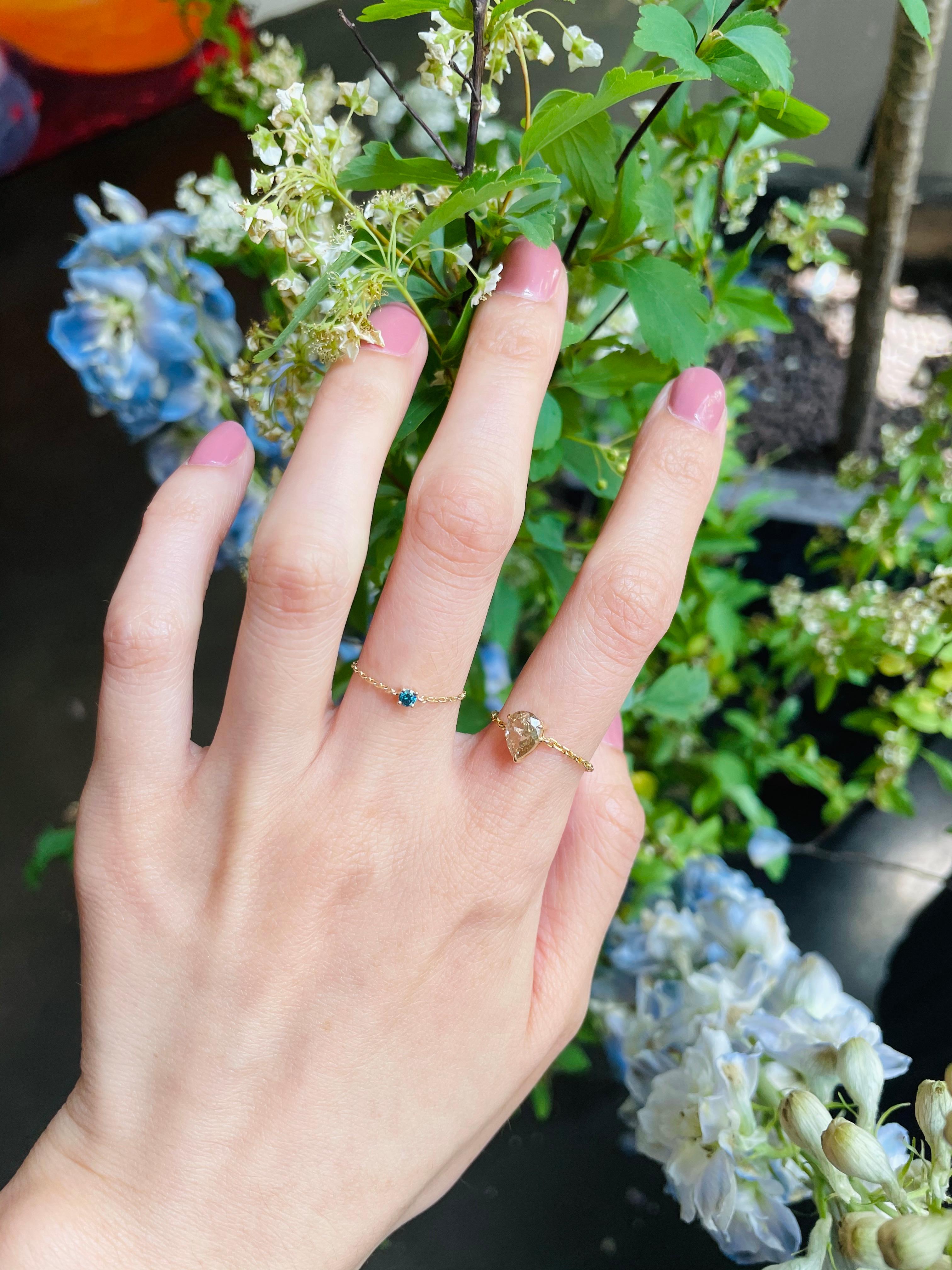 A sweet little blue Diamond chain ring set in 14k gold packing a whole lot of shine. This natural diamond in a teal blue color is truly something special.

It is perfect by itself or stacked with other rings from our collections. We call these our