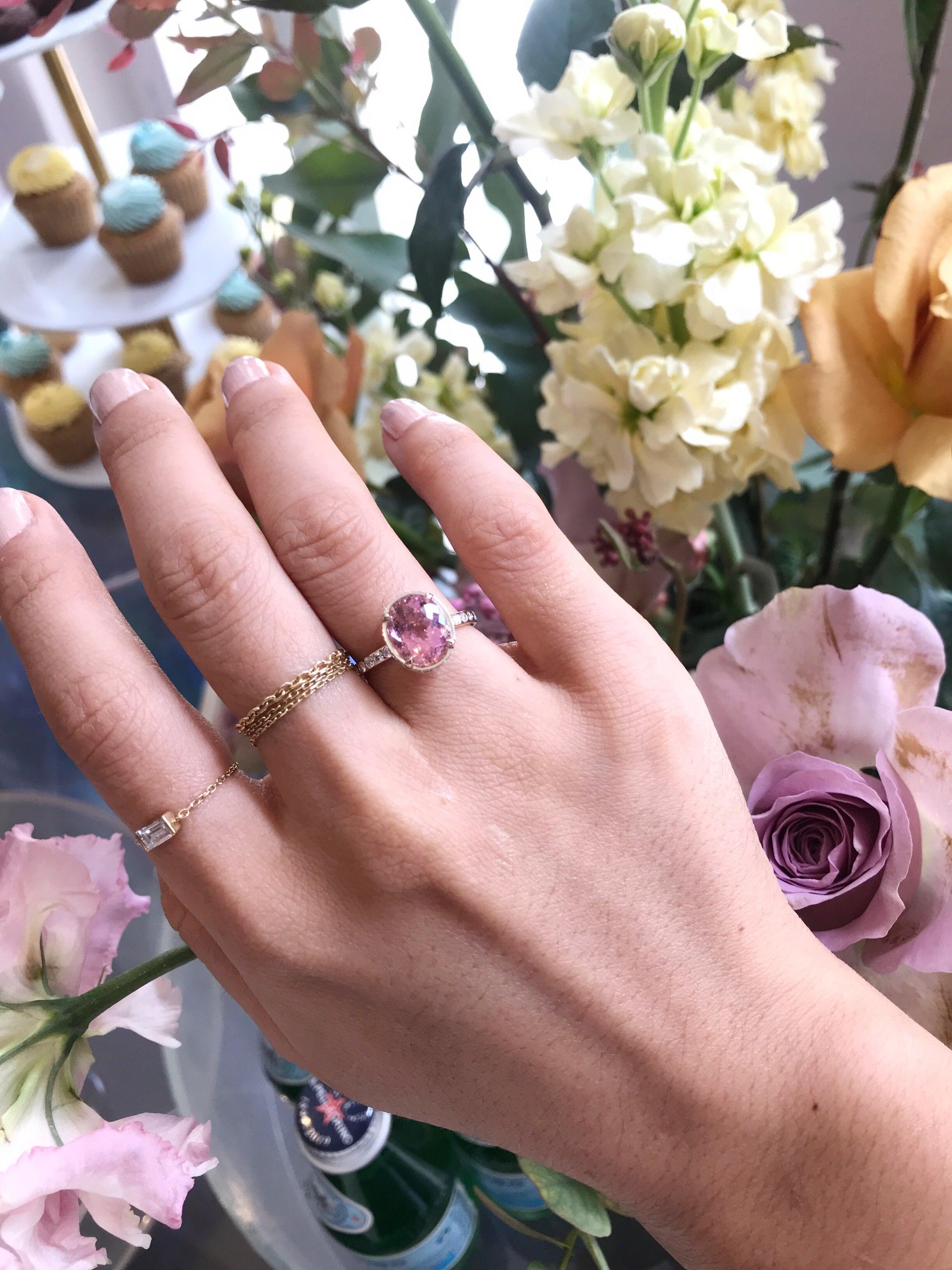 This Pink Tourmaline and Diamond halo ring is a feminine and modern classic. The elegant and modern design features a pink tourmaline propped up by a halo of white diamond just beneath the prong setting. This intricate and elegant center stone