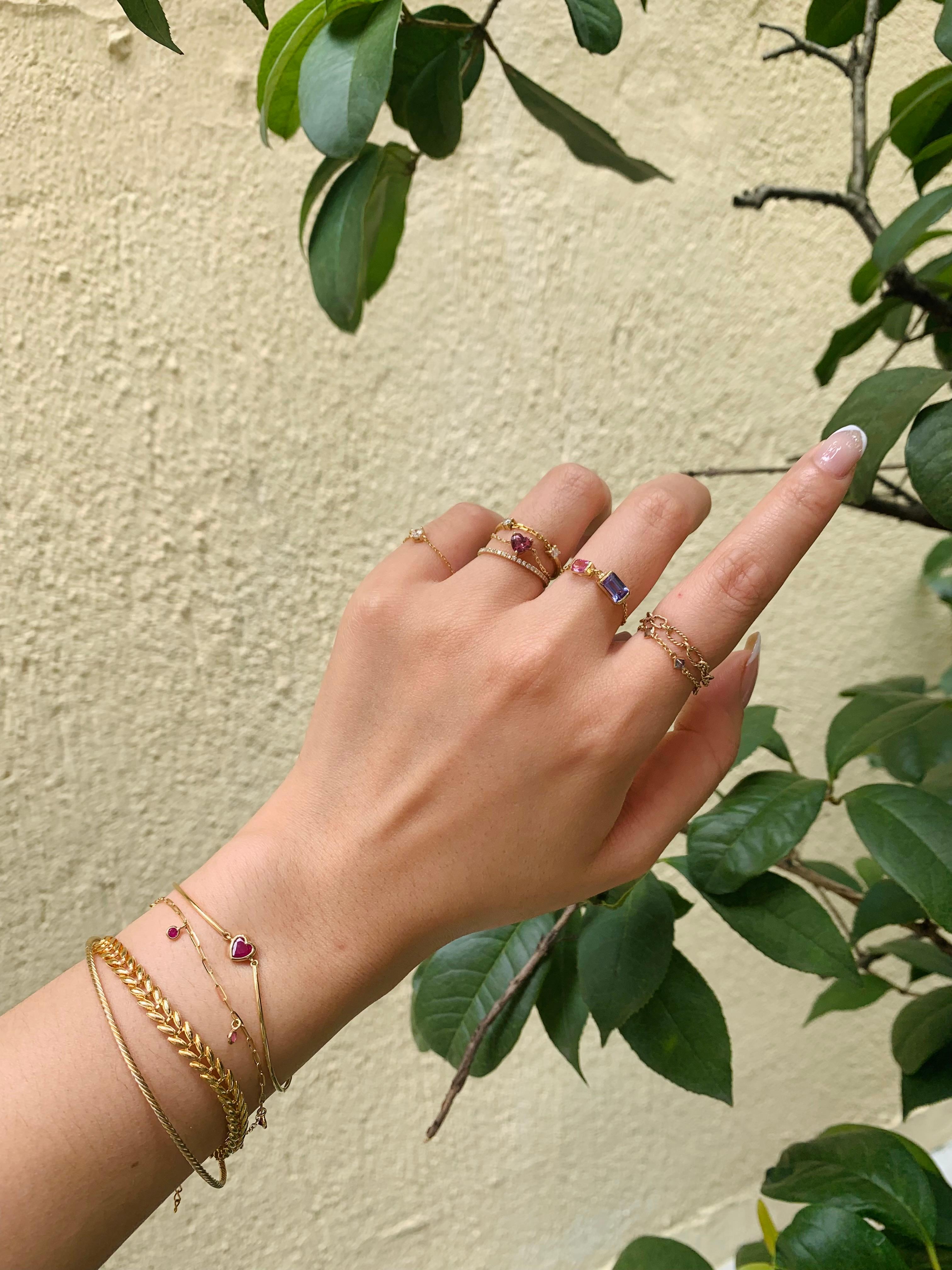 These perfectly feminine and romantic gemstones come together in an unexpected modern way.  An emerald cut tanzanite in the most wonderful shade of lilac purple is paired with a bubblegum pink sapphire. 

Tanzanites are among the rarest of all