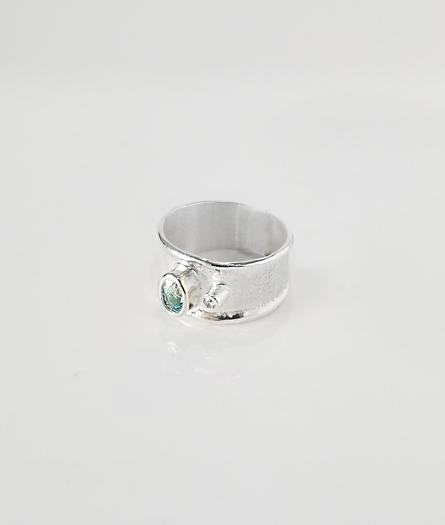 Enjoy Yianni Creations fine silver artisan ring from Ammos Collection featuring 0.40 Carat aquamarine accompanied by 0.03 Carat brilliant cut white diamond. The unique look of this simplified band is created by ancient techniques of craftsmanship -