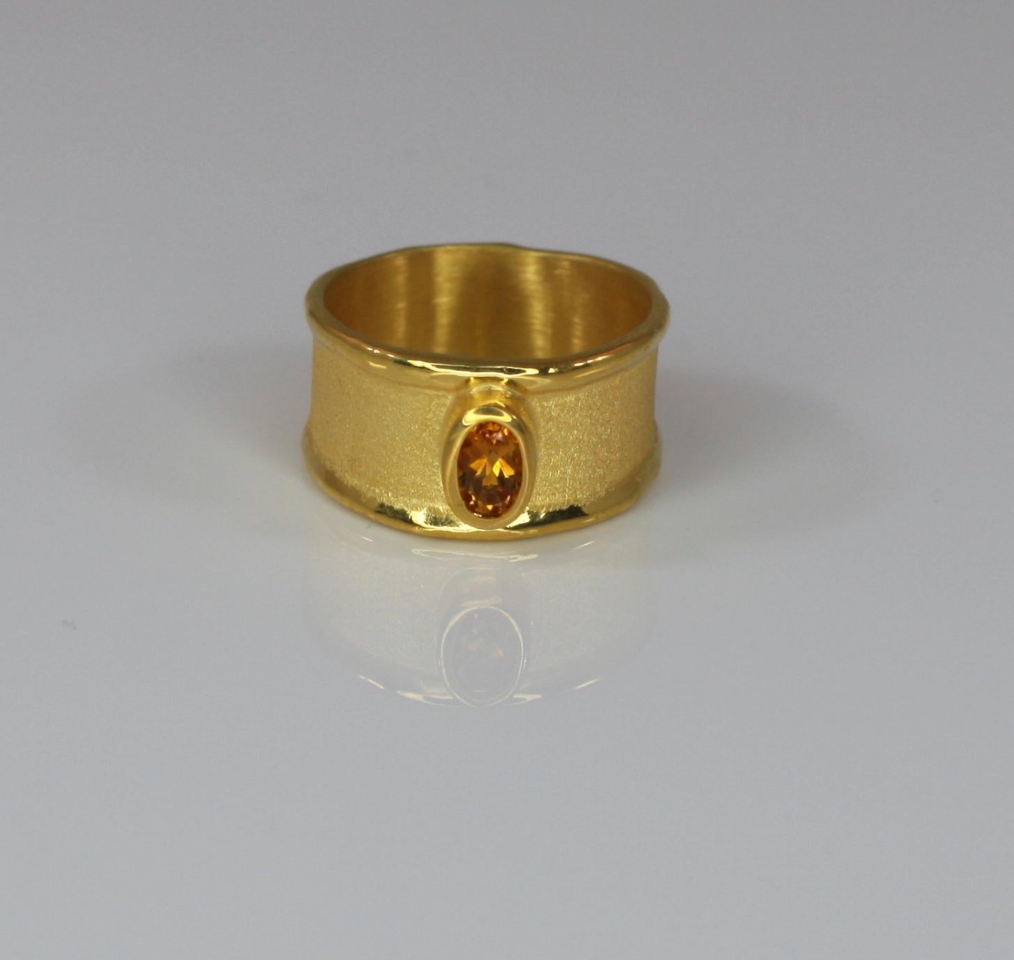 Yianni Creations fully handmade artisan band ring made from 18 Karat yellow gold and features 0.45 Carat oval-shape Citrine. This tone in tone gorgeous band attracts by its simplicity and by its unique techniques of craftsmanship - brushed texture
