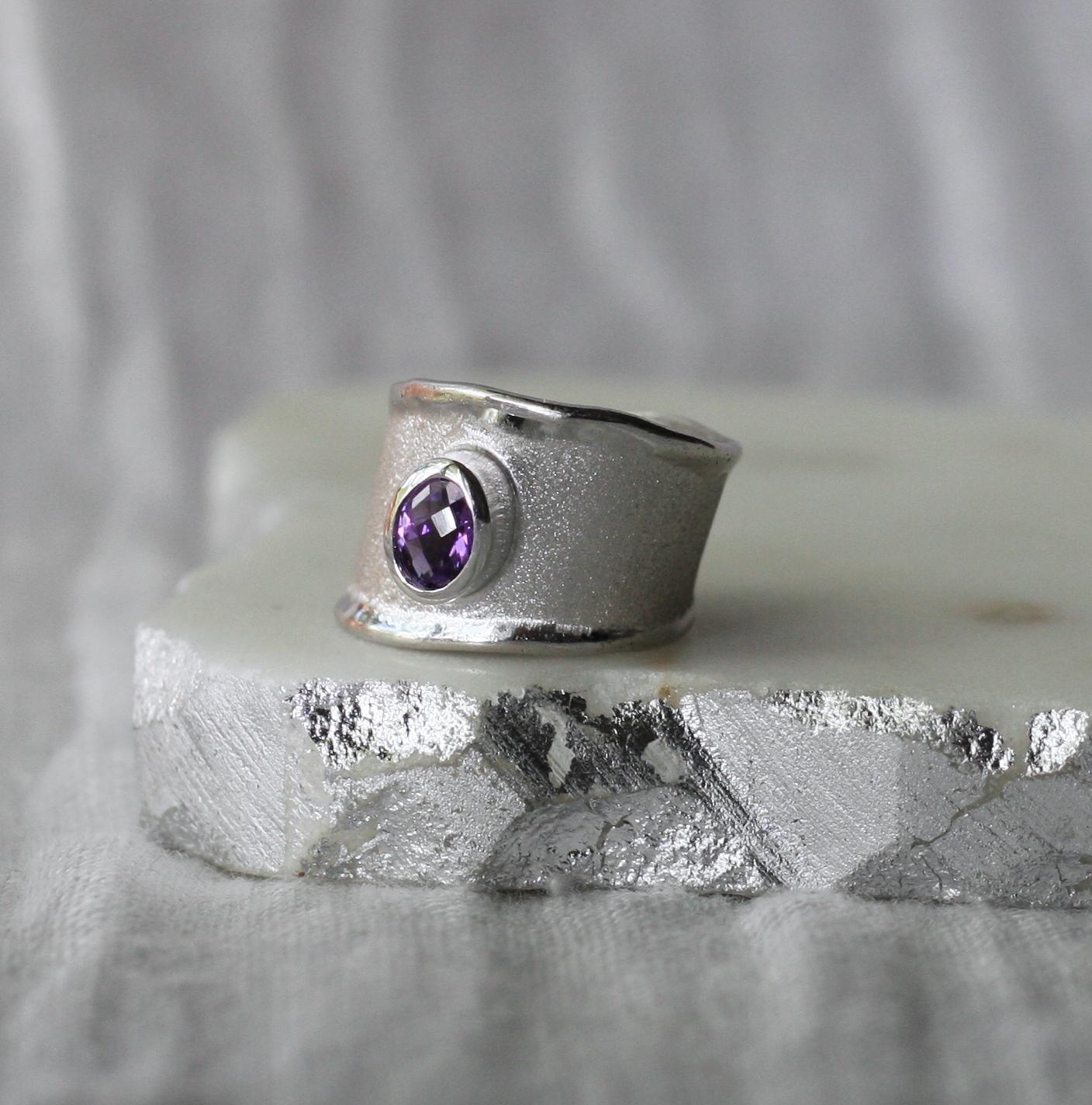 Presenting Yianni Creations fine silver artisan ring from Ammos Collection featuring 0.85 Carat oval cut amethyst. The unique look of this simplified band is created by ancient techniques of craftsmanship - brushed texture and nature-inspired liquid