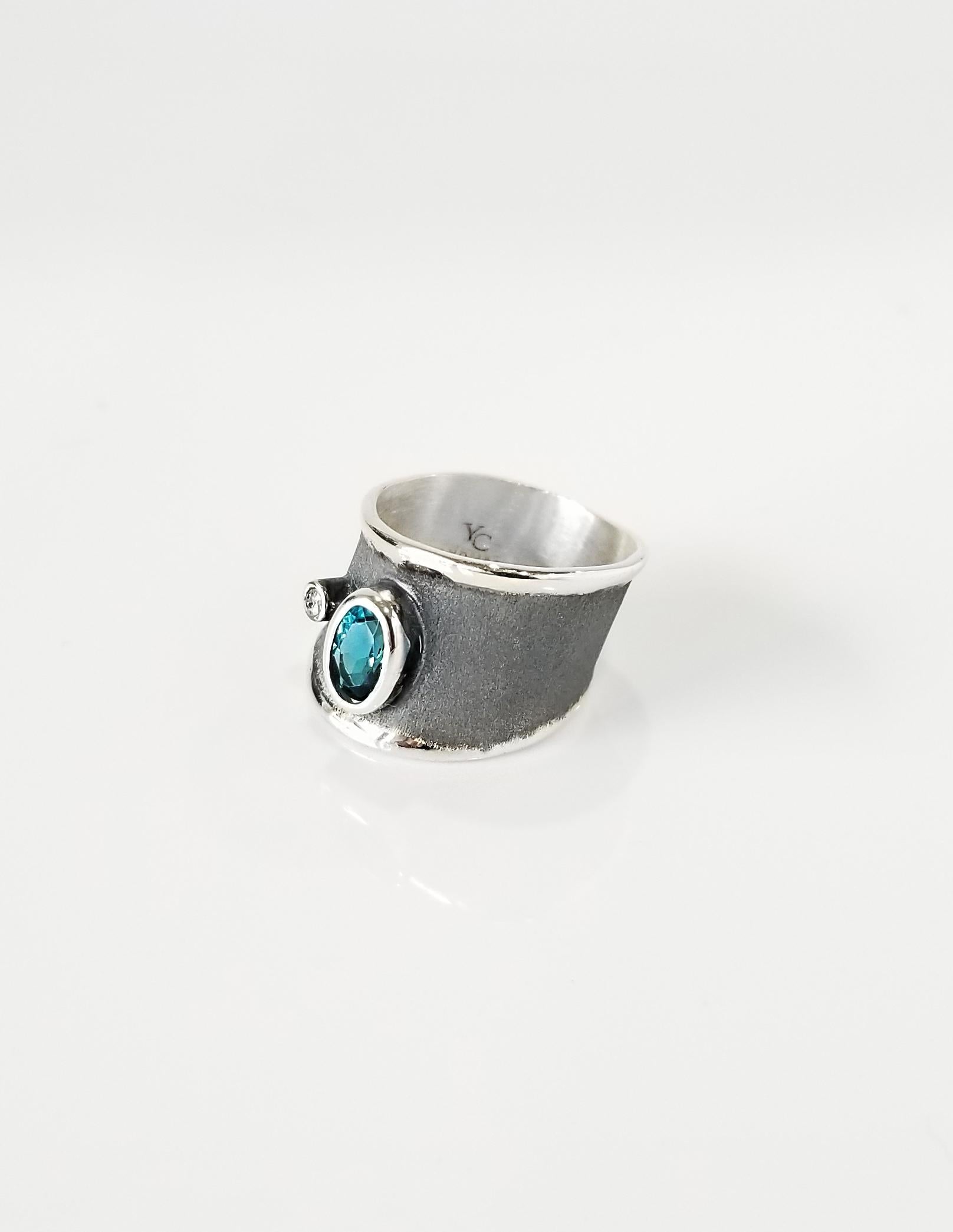 Yianni Creations Hephestos Collection 100% handgefertigter handwerklicher Ring aus Feinsilber. Der Ring verfügt über 1,1 Karat Oval Cut London Blue Topaz und 0,03 Karat Brillantschliff Diamant kontrastierenden auf einzigartige oxidierte Rhodium