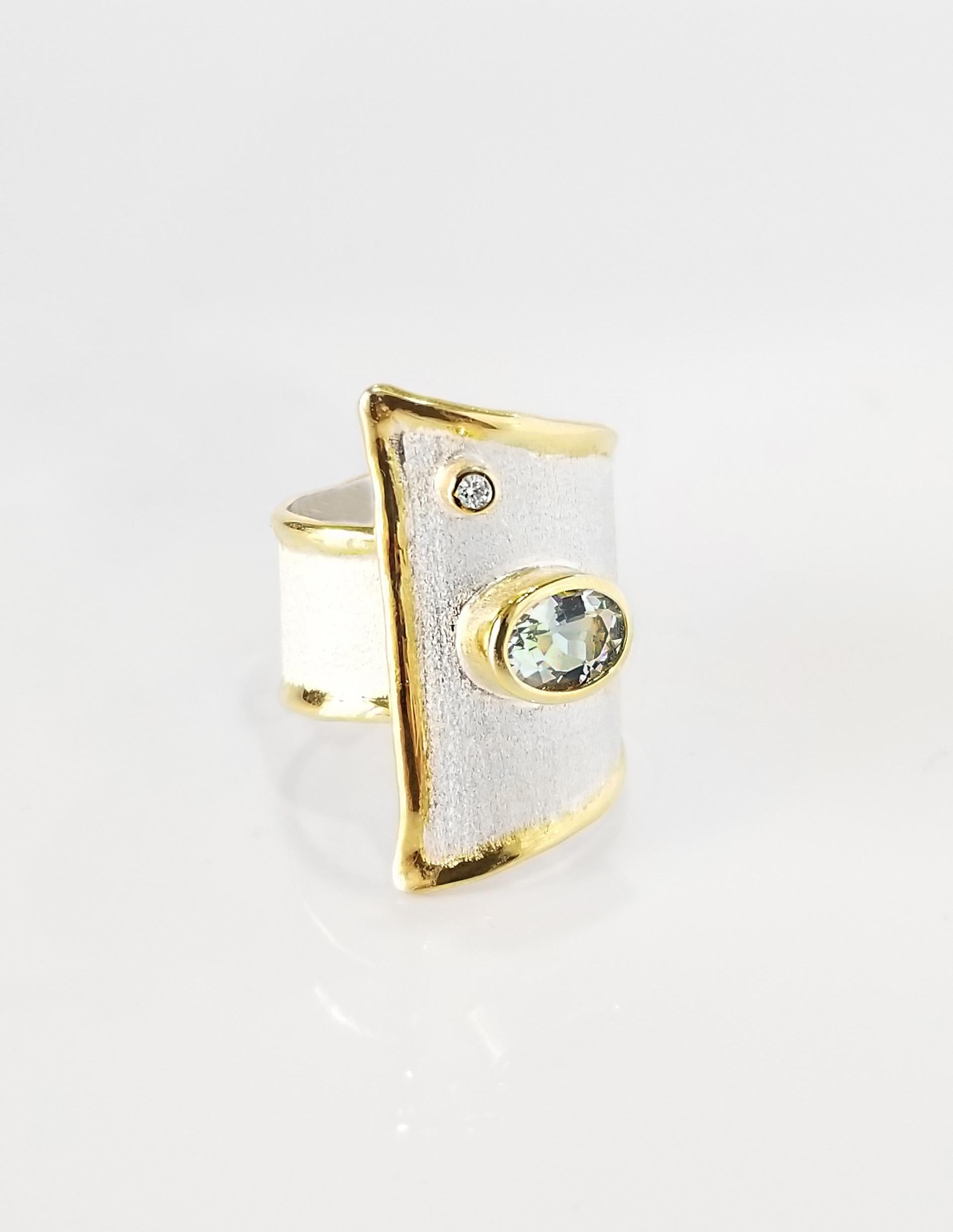 Yianni Creations artisan silver ring from Midas Collection handcrafted in Greece. This adjustable ring is plated with palladium to resist elements and the edges are decorated with an overlay of 24 Karat Yellow Gold and feature 1.10 Carat aquamarine
