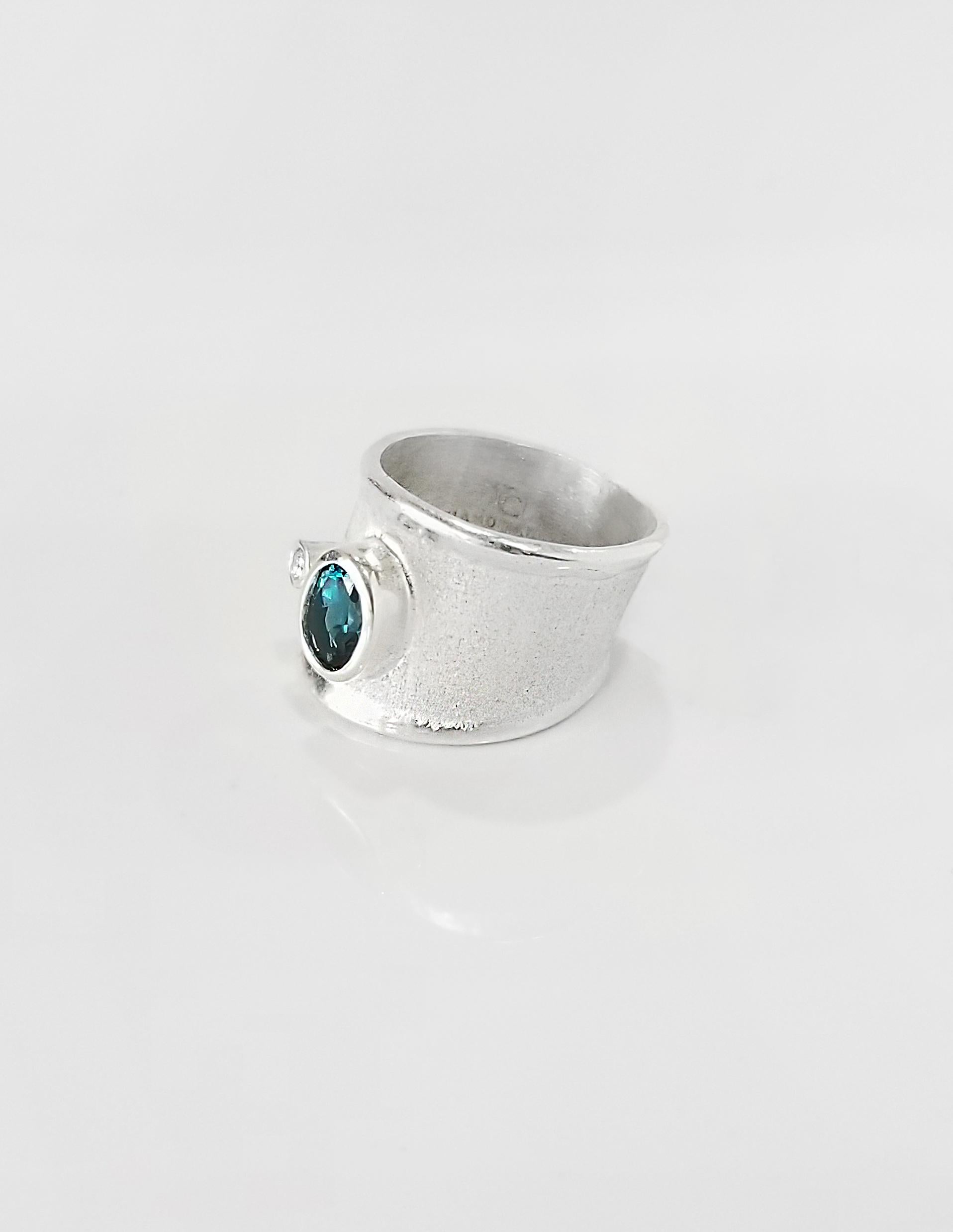 Yianni Creations Ammos Collection handcrafted artisan ring from fine silver 950 purity plated with palladium to resist the elements. This ring is featuring 1.10 Carat London Blue Topaz accompanied by 0.03 Carat Brilliant Cut White Diamond