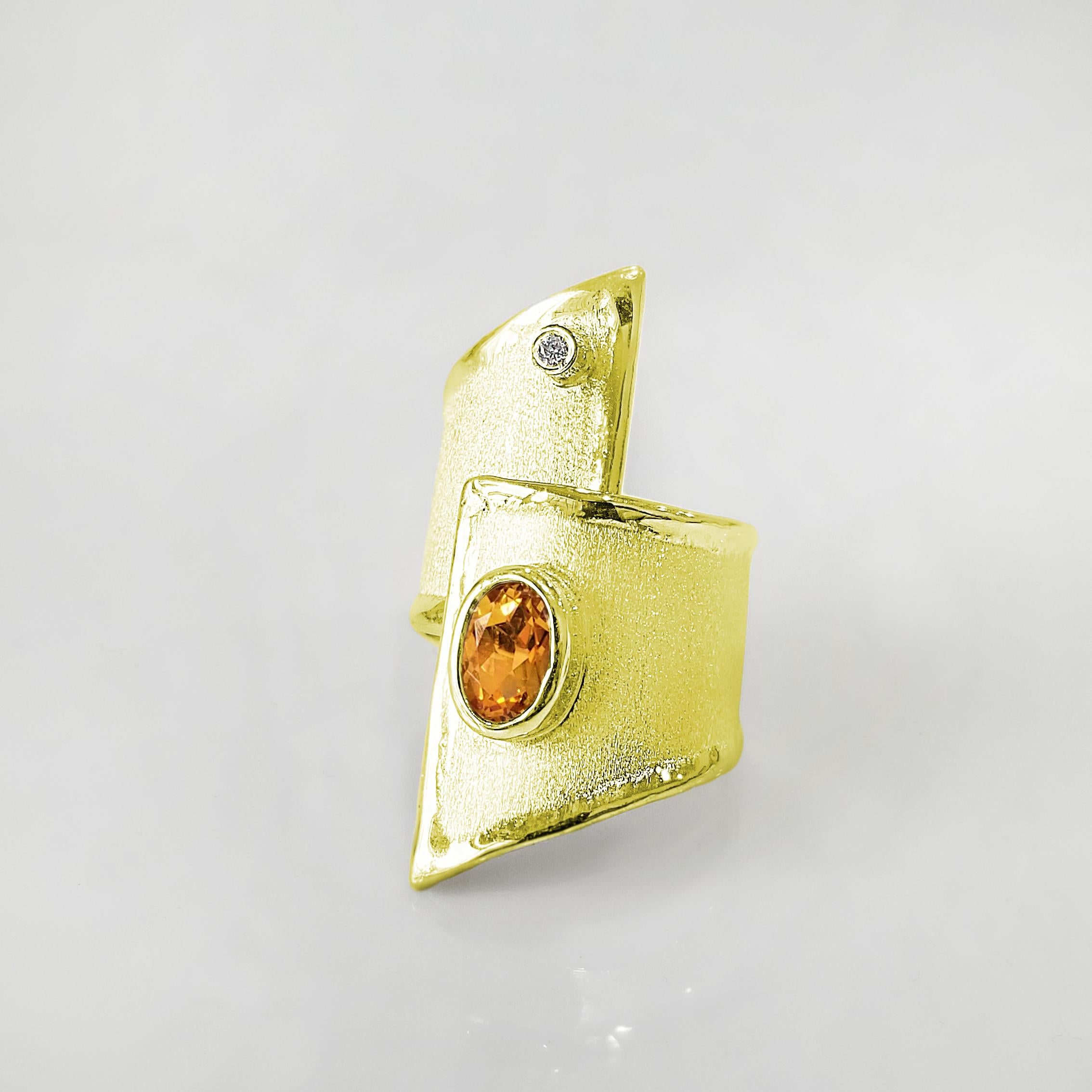 L'anello a fascia larga Yianni Creations da 18 carati è realizzato a mano in Grecia e presenta un Citrino ovale da 1,25 carati accompagnato da un Diamante bianco da 0,03 carati a taglio brillante. La texture spazzolata e i bordi liquidi ispirati