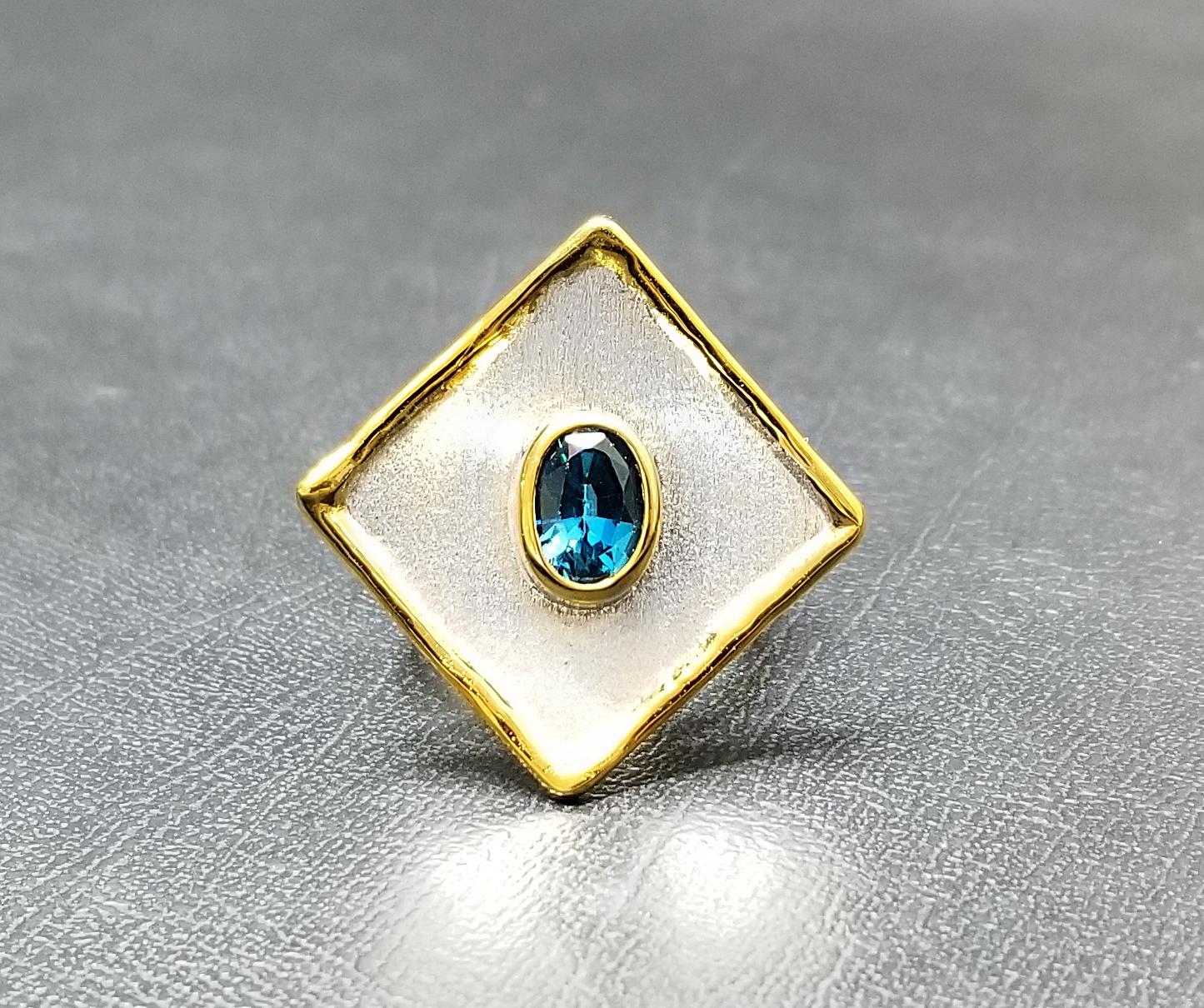 Presenting Yianni Creations ring from Ammos Collection, which was handmade in Greece from fine silver plated with palladium to resist the elements. This geometric-shaped ring features a 1.60 Carat London blue topaz and the gold touch on liquid edges