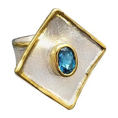Yianni Kreationen Zweifarbiger Ring mit blauem Topas aus feinem Silber und 24 Karat Gold