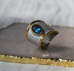 Yianni Creations Verstellbarer breiter Bandring mit blauem Topas aus feinem Silber 24 Karat Gold