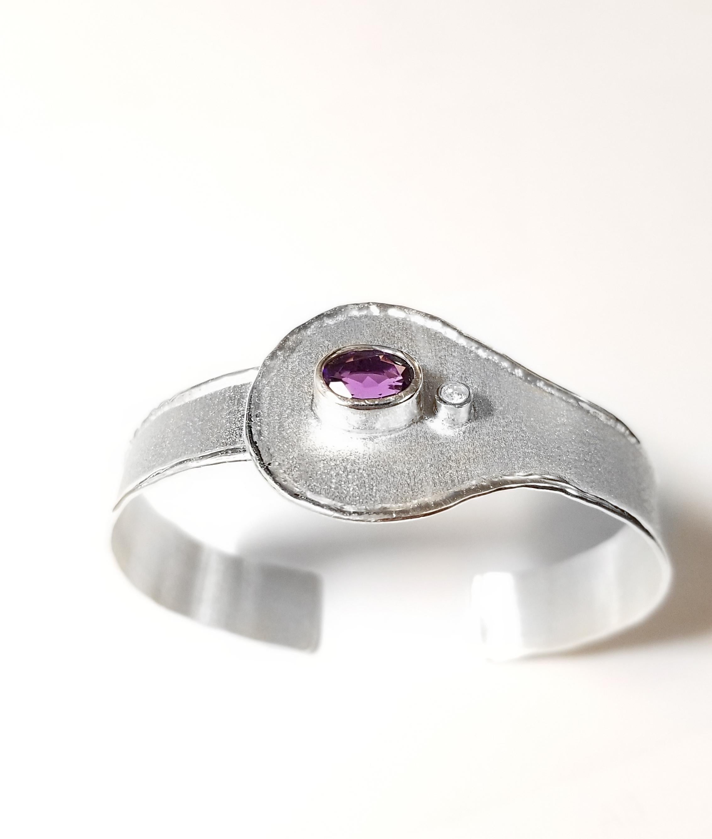 This is Yianni Creations all handmade artisan bangle bracelet from Ammos Collection crafted from Fine Silver in Greece. This adjustable bracelet features 1.75 Carat oval cut Amethyst accompanied by 0.03 Carat brilliant-cut diamond. The unique look