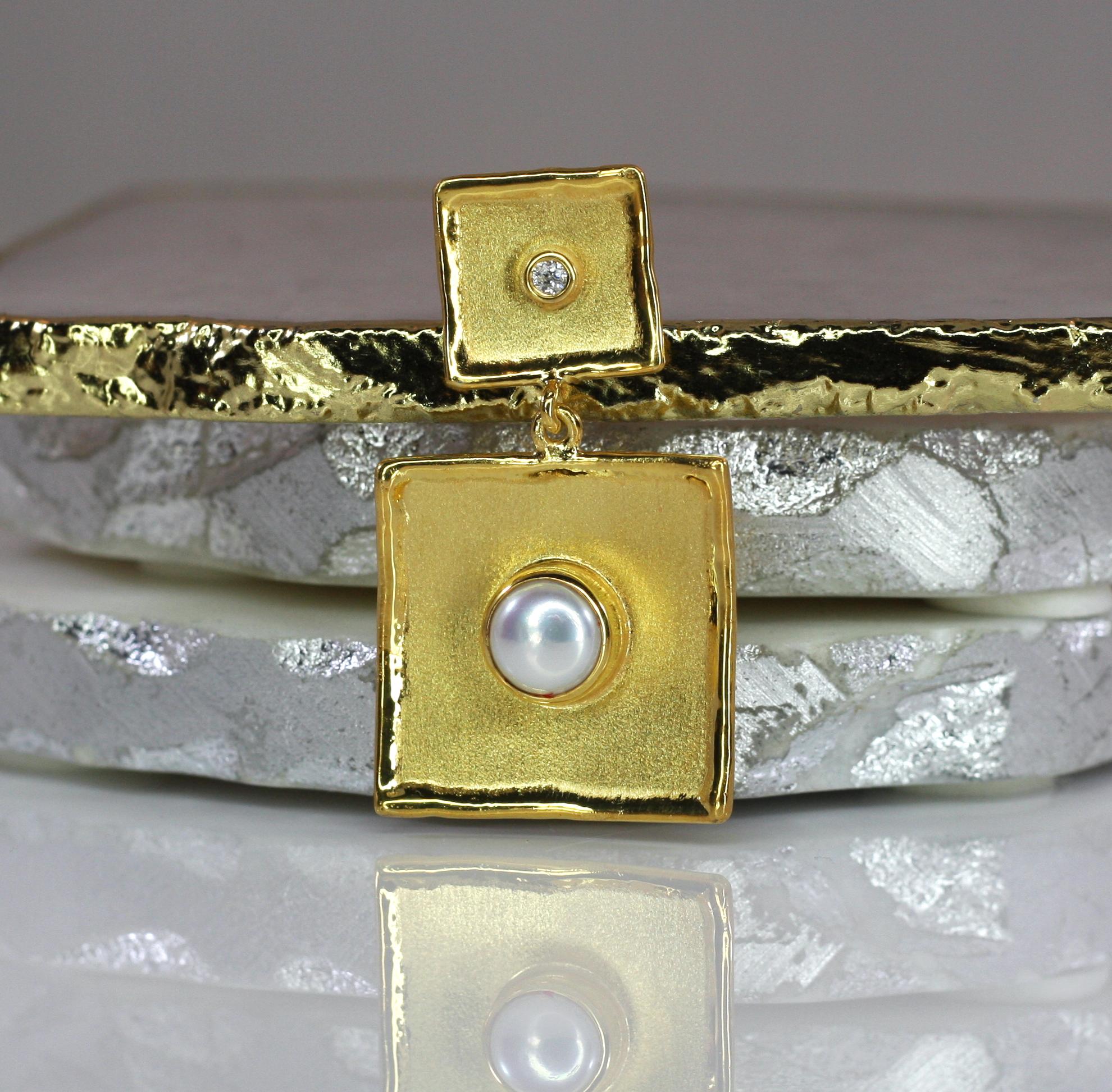 This is Yianni Creations handmade artisan slide crafted in Greece from 18 Karat Yellow Gold. This square-shaped dangle pendant features 7MM freshwater pearl and 0.03 Carat brilliant cut Diamond. The unique look is created by combining two ancient
