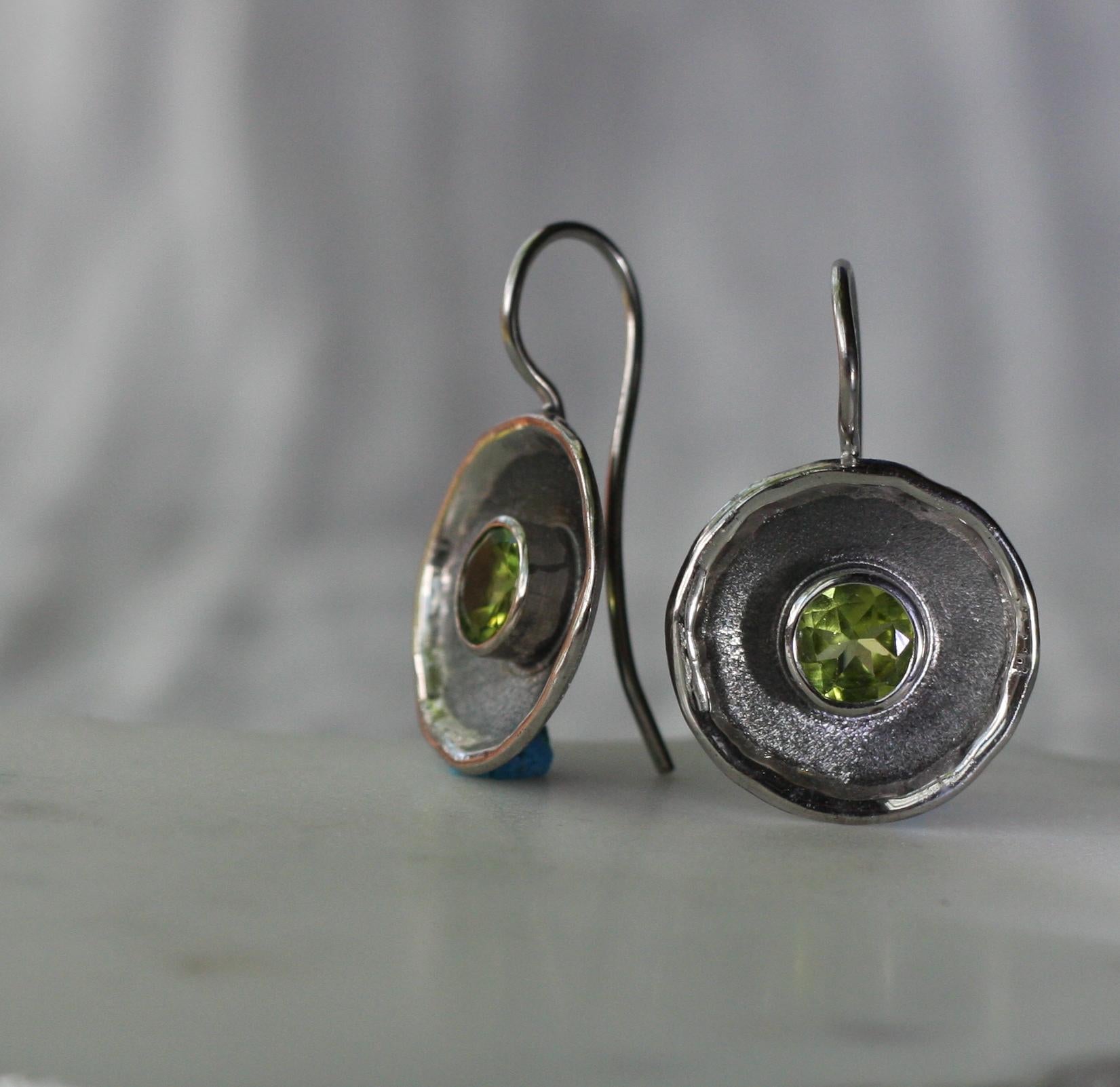 Yianni Creations präsentiert Ohrringe aus der Hephestos-Kollektion. Diese Ohrringe sind alle aus 950er Feinsilber handgefertigt und mit Palladium beschichtet, um sie vor Anlaufen zu schützen. Jeder Ohrring besteht aus einem 1,25-karätigen Peridot,