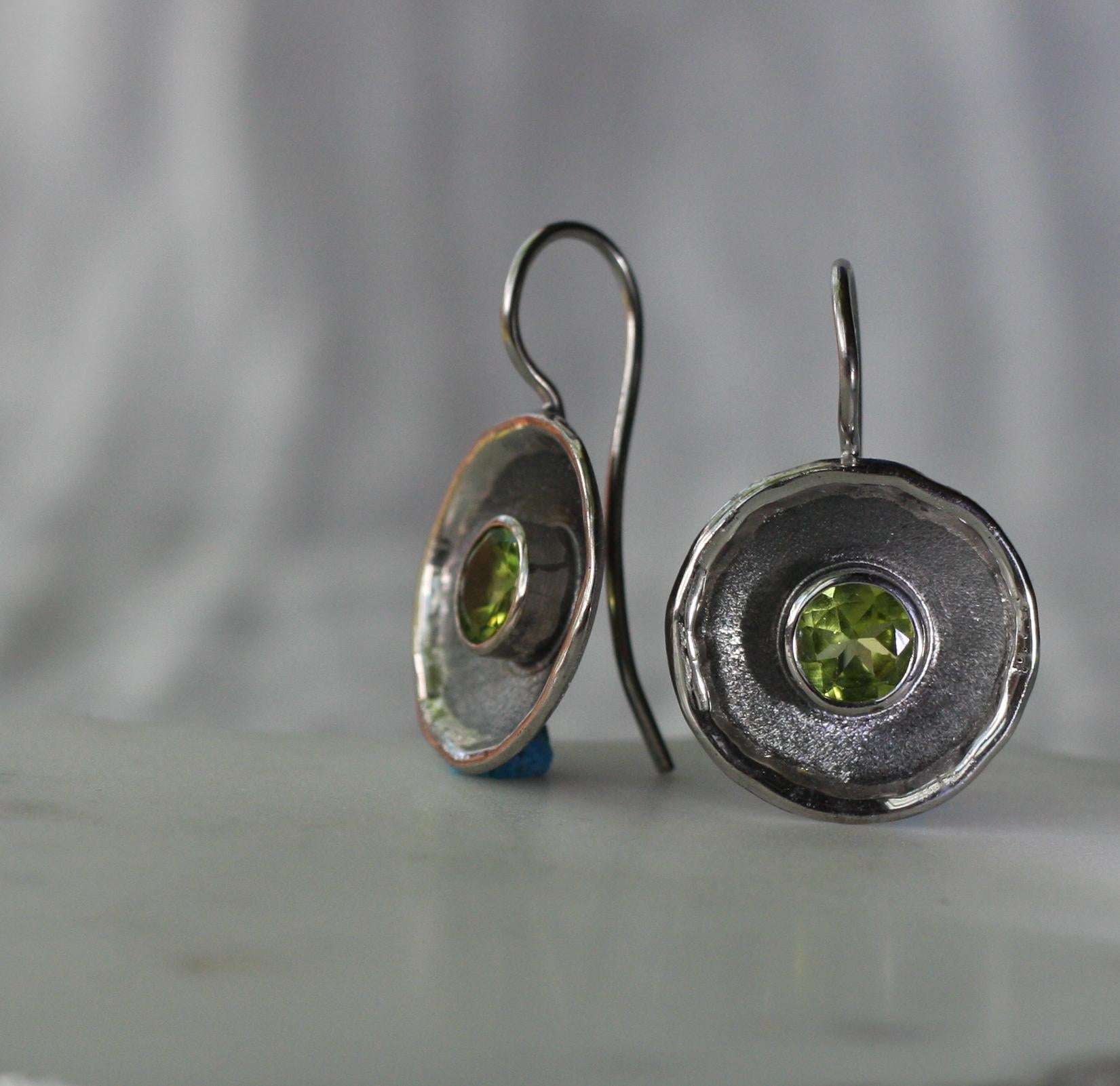 Yianni Creations presenta los pendientes de la Colección Hephestos. Estos pendientes están hechos a mano con plata fina de 950 de pureza y chapados con paladio para protegerlos del deslustre. Cada pendiente presenta un Peridoto de 1,25 quilates