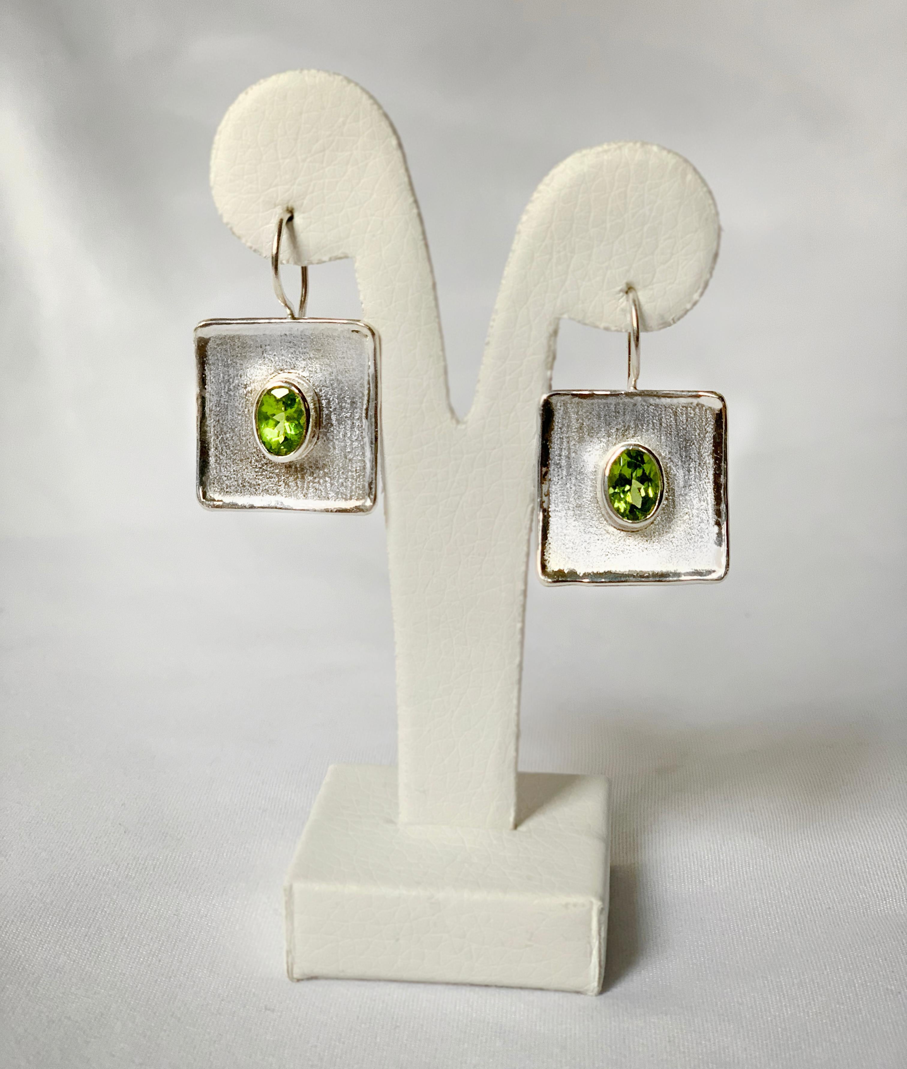 Son pendientes colgantes de plata fina Yianni Creations, hechos a mano para la Colección Ammos en Grecia. Cada uno de estos pendientes artesanales presenta un Peridoto de talla oval de 1,35 quilates. El aspecto único se crea utilizando antiguas