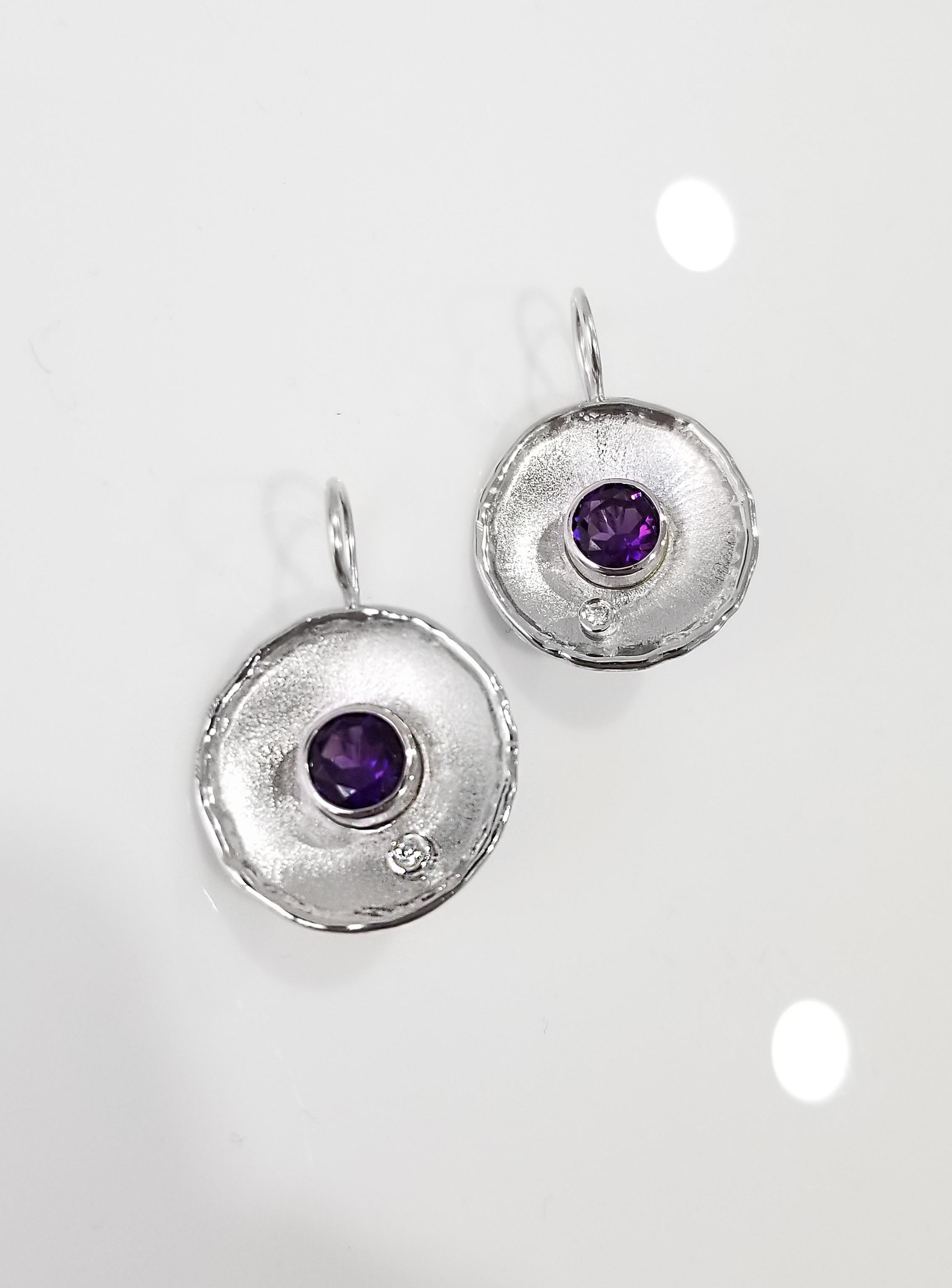 From Yianni Creations Ammos Collection, this is handmade artisan earrings from a fine silver plated with palladium to resist against elements. Each earring features 1.80 carat round cut Amethyst complimented by 0.03-carat brilliant cut diamond.