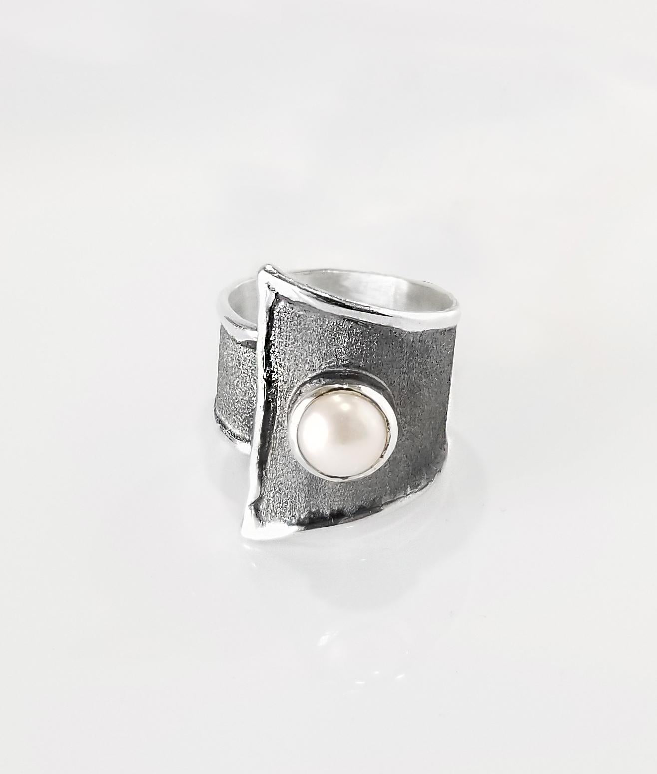 Yianni Creations Hephestos Collection 100% Handmade Artisan Ring from Fine Silver. The ring features a 7 - 7.5 mm Freshwater Pearl contrasting on unique oxidized Rhodium background complemented by unique techniques of craftsmanship - brushed texture