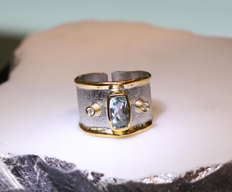 Yianni Creations band ring with rectangular shaped 2.20 Carat Aquamarine complemented by two brilliant-cut diamonds of total weight 0.06 Carat. This wonderful aquamarine ring is made open to fit any size since our creations cannot be sized due to