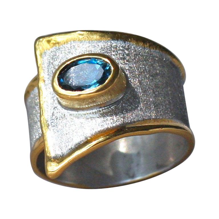 Yianni Creations Anillo ancho de topacio azul de plata fina y oro de 24 quilates en dos tonos