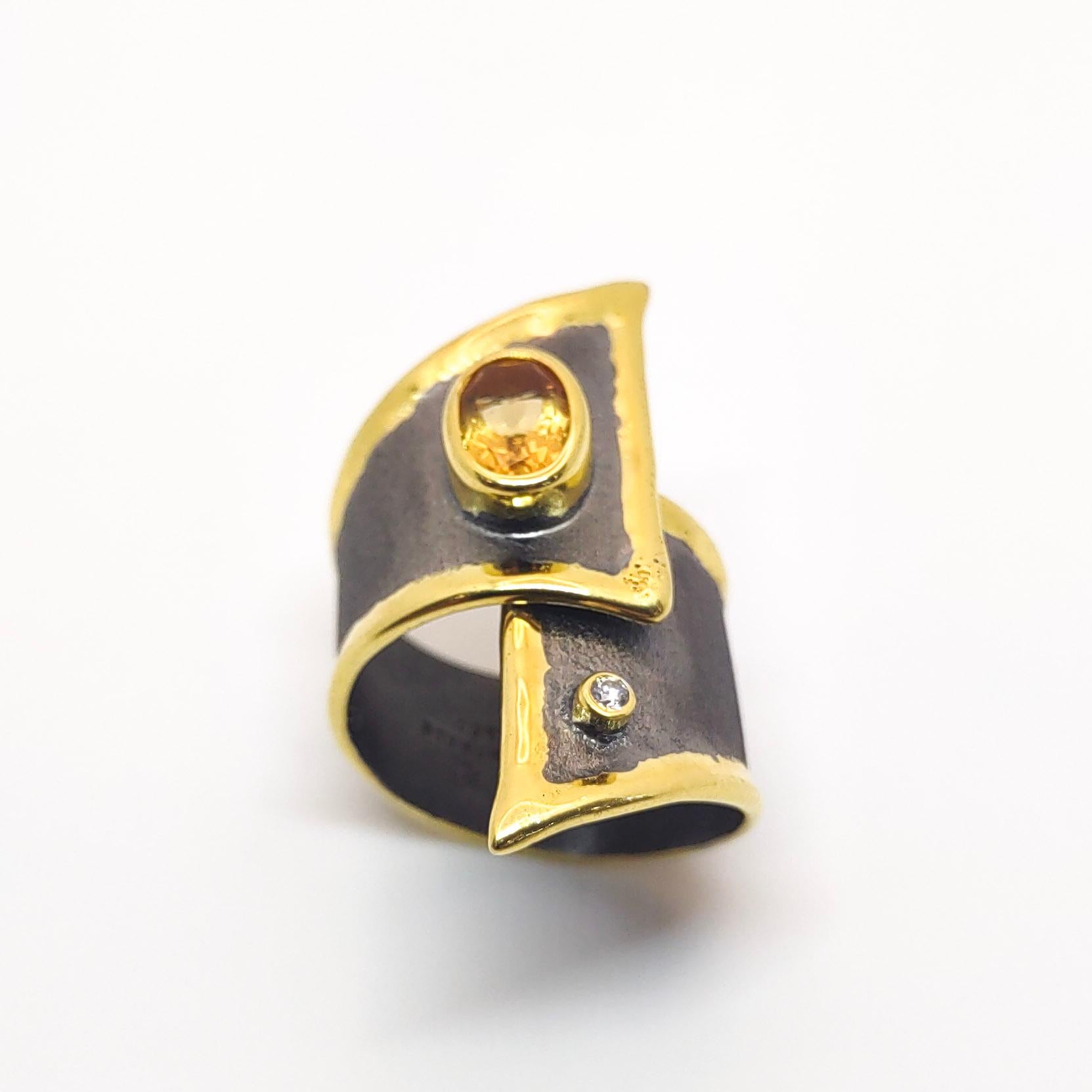 Yianni Creations présente une bague artisanale Eclyps Collection faite à la main à partir d'argent fin 950 pureté plaqué rhodium noir. Cette large bague asymétrique présente une citrine de 1,25 carat accompagnée d'un diamant blanc de 0,03 carat sur