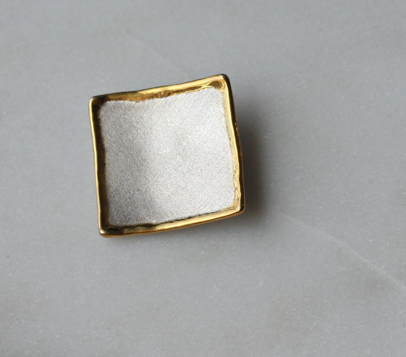 Ti presentiamo il pendente di Yianni Creations dalla forma geometrica della collezione Midas, realizzato a mano in argento 950 e placcato in palladio per resistere agli agenti atmosferici. Questo ciondolo artigianale nella sua purezza attrae per la