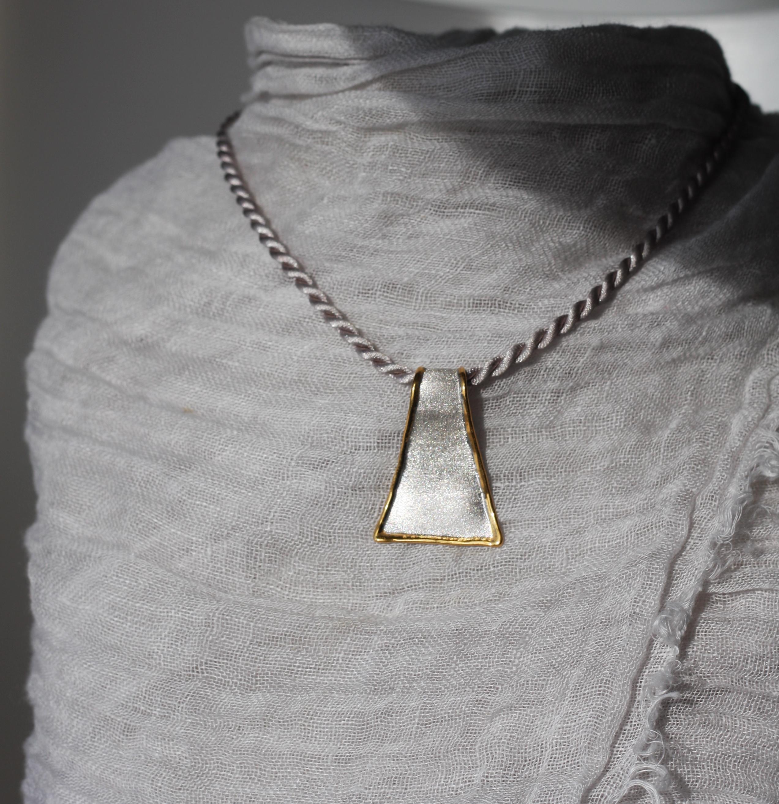 This is a triangular shape Yianni Creations pendant from Midas Collection all handmade in Greece from fine silver 950 purity and plated with palladium to resist tarnish. This artisan pendant enhancer in its purity shines due to its texture. The
