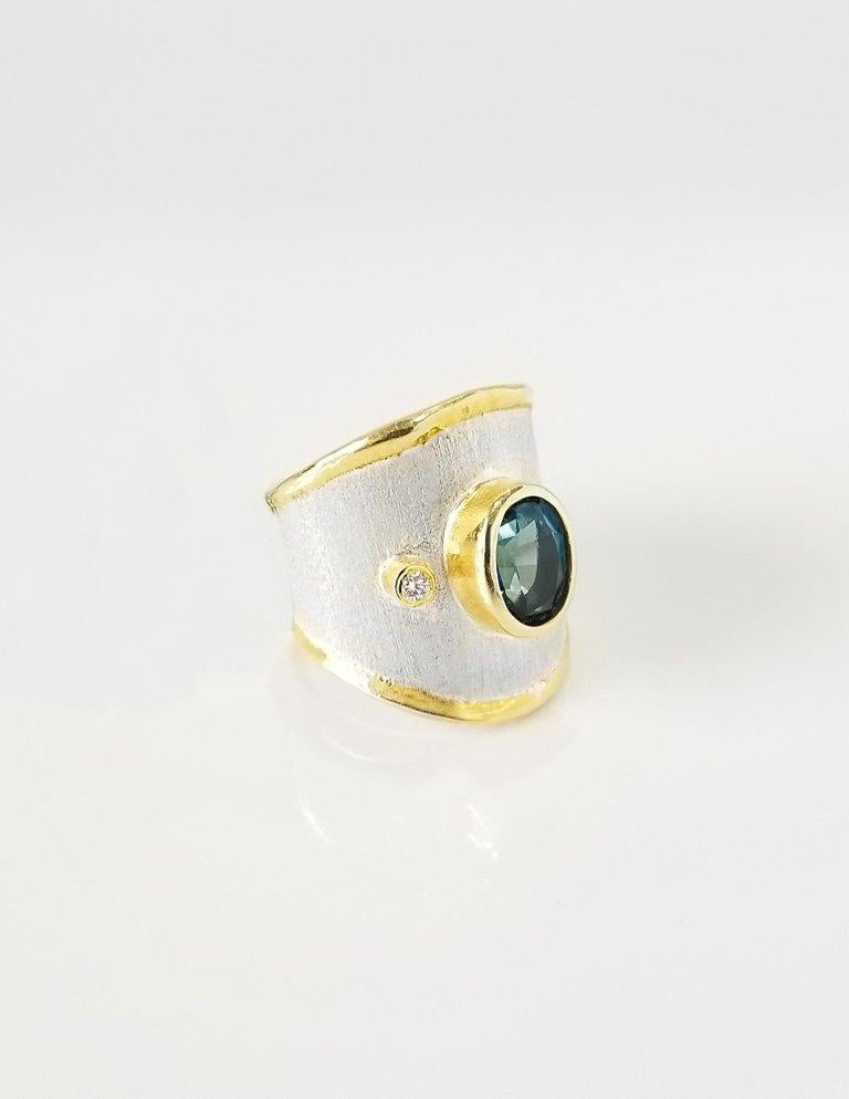 Dieser zweifarbige handgefertigte Designer-Ring von Yianni Creations ist aus 950er Feinsilber gefertigt und mit einer Auflage aus 3+ Mikron 24 Karat Gelbgold versehen. Dieser wunderschöne Ring besteht aus einem natürlichen Londoner Blautopas im