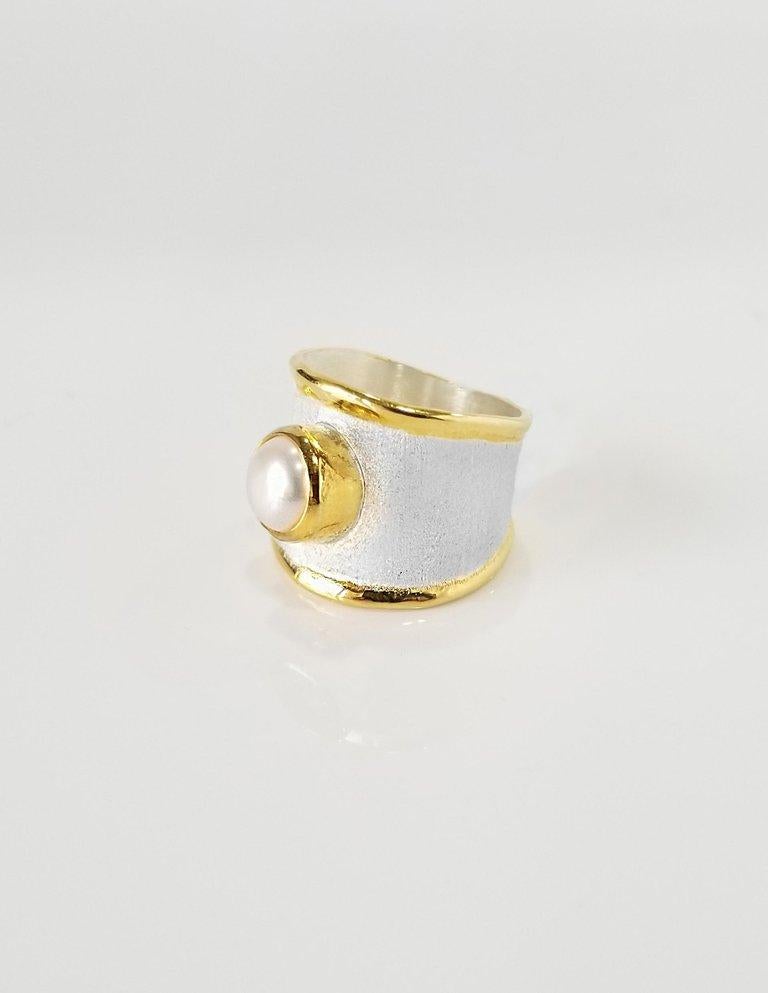 Yianni Creations designer Band Ring is all hand made from Fine Silver with a layover of 24 Karat Yellow Gold features a 7.0 mm Freshwater Pearl complemented by a unique technique of craftsmanship - brushed texture and nature-inspired liquid edges.