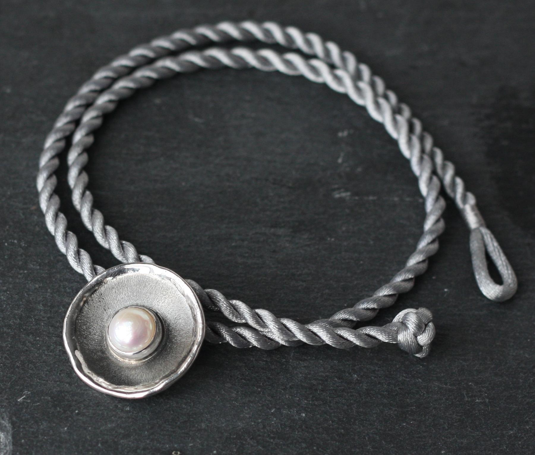 Dalla collezione Hephestos di Yianni Creations, questo scivolo è realizzato a mano in argento 950 di elevata purezza e placcato in palladio per resistere agli agenti atmosferici. Questo ciondolo è caratterizzato da una perla d'acqua dolce rotonda di