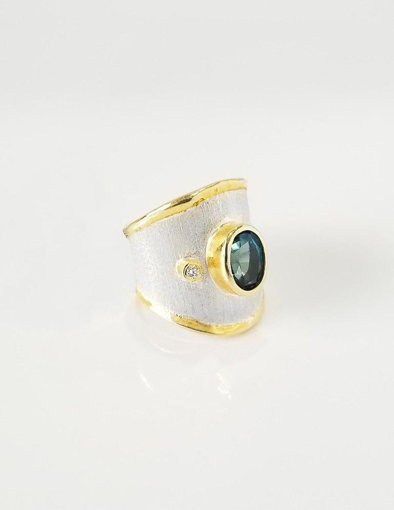 Yianni Creations Midas Collection 100% handgefertigter Artisan Ring aus Feinsilber mit einem Overlay aus 24 Karat Gelbgold verfügt über einen 1,60 Karat Oval Cut London Blue Topaz begleitet von 0,03 Karat Diamanten ergänzt durch einzigartige