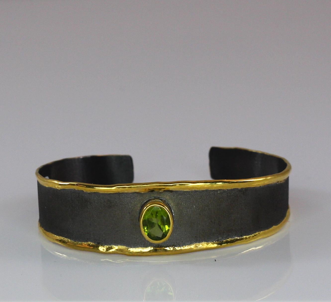 Yianni Creations cuff bracelet crafted in Greece for Eclyps Collection from fine silver 950 purity and plated with Black Rhodium which is the most valuable metal. This gorgeous handmade artisan bangle cuff bracelet features an oval natural Peridot