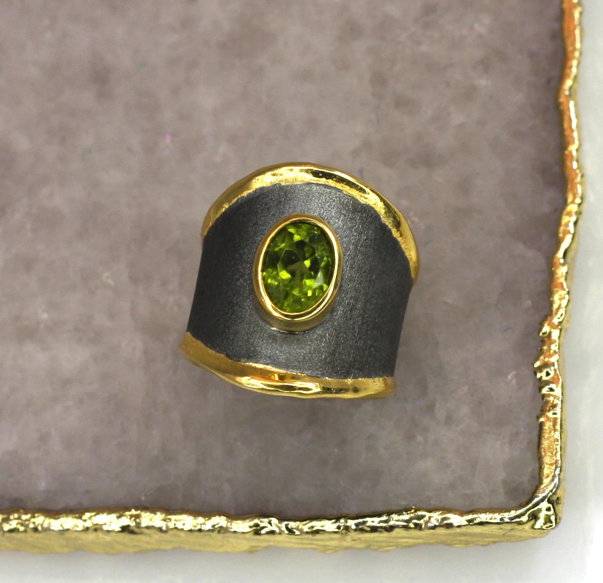 Dieser breite Ring von Yianni Creation besteht aus Feinsilber mit 950er Reinheit und einer 24-karätigen Goldauflage von 3+ Mikron und wird in Griechenland handgefertigt. Dieser wunderschöne Ring ist mit schwarzem Rhodium überzogen und mit einem