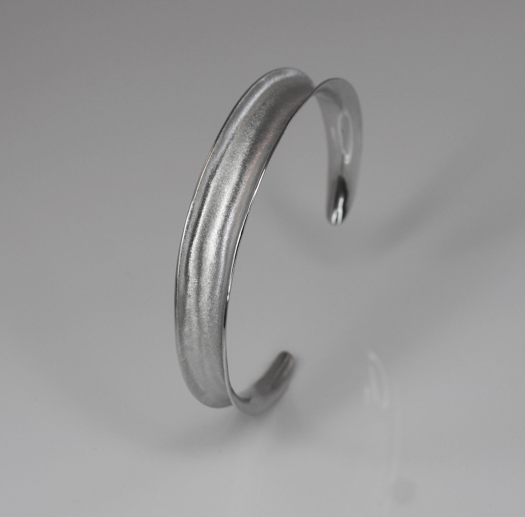 Yianni Creations artisan bracelet from handcrafted in Greece from fine silver 950 purity and plated with palladium to resist against the elements. This elegant bangle bracelet is featuring a unique surface created by the ancient technique of
