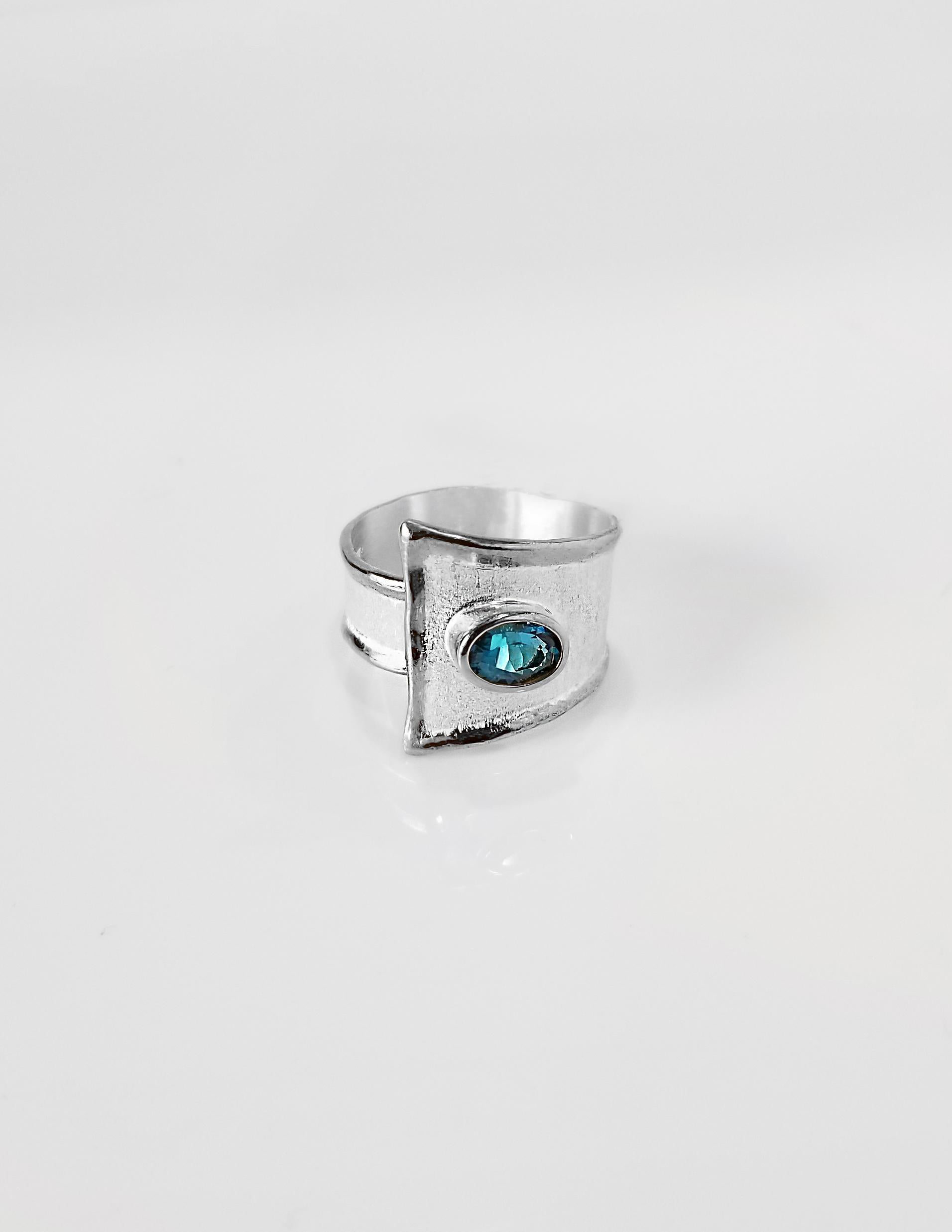 Yianni Creations Ammos Collection 100% handgefertigter Ring aus Feinsilber mit 1,60 Karat Londoner Blautopas, ergänzt durch einzigartige Handwerkstechniken - gebürstete Textur und von der Natur inspirierte flüssige Kanten. Das Herzstück dieses