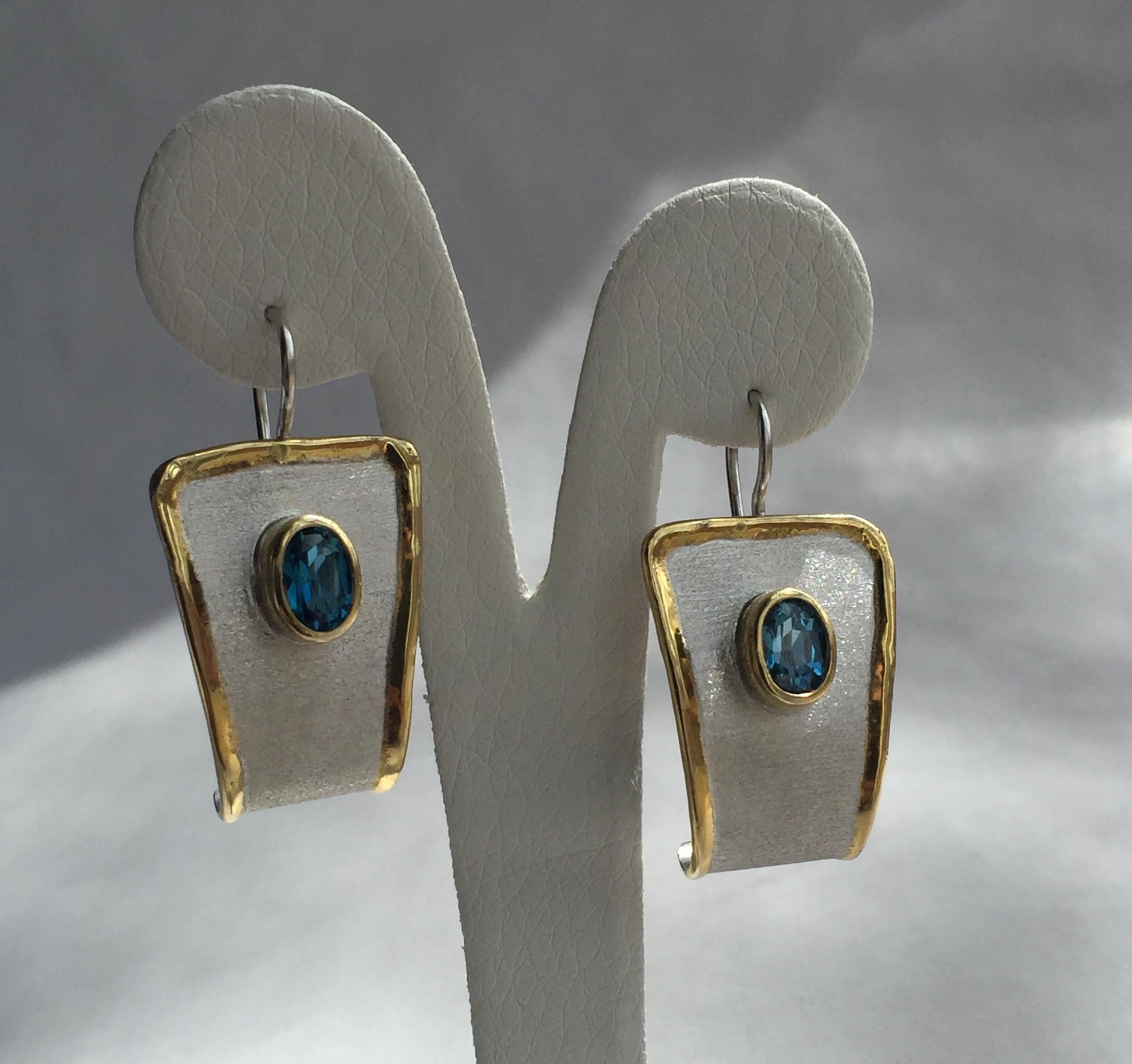 Yianni Creations Midas Collection Boucles d'oreilles pendantes en argent fin 100% fait main par des artisans. Chaque boucle d'oreille est ornée d'une topaze bleue de Londres de 1,60 carat à taille ovale, complétée par des techniques artisanales