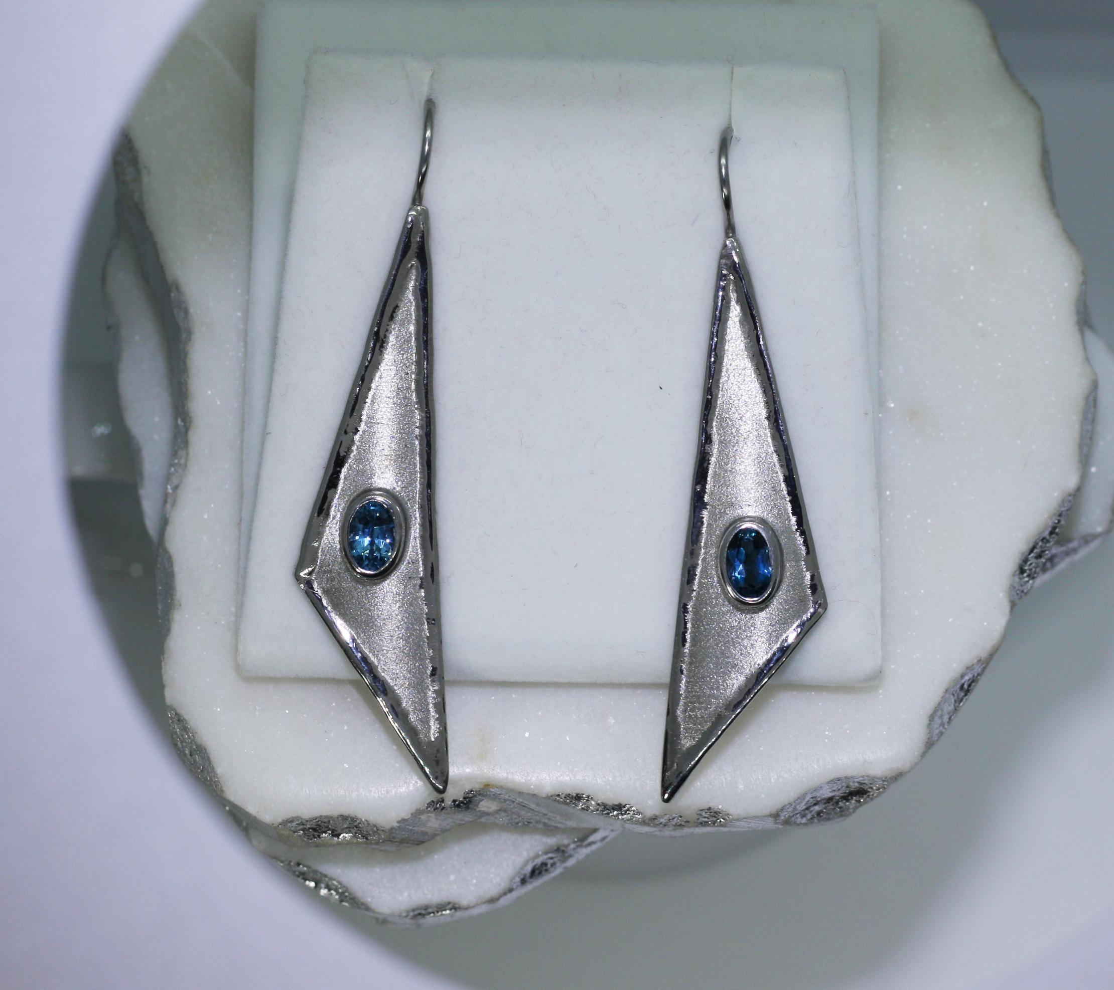 Yianni Creations dangle earrings have been crafted in Greece for Eclyps Collection. This is our bigger size style gorgeous earring all 100% Handmade from Fine Silver 950 purity and features 1.60 Carat Oval Cut London Blue Topaz complemented by