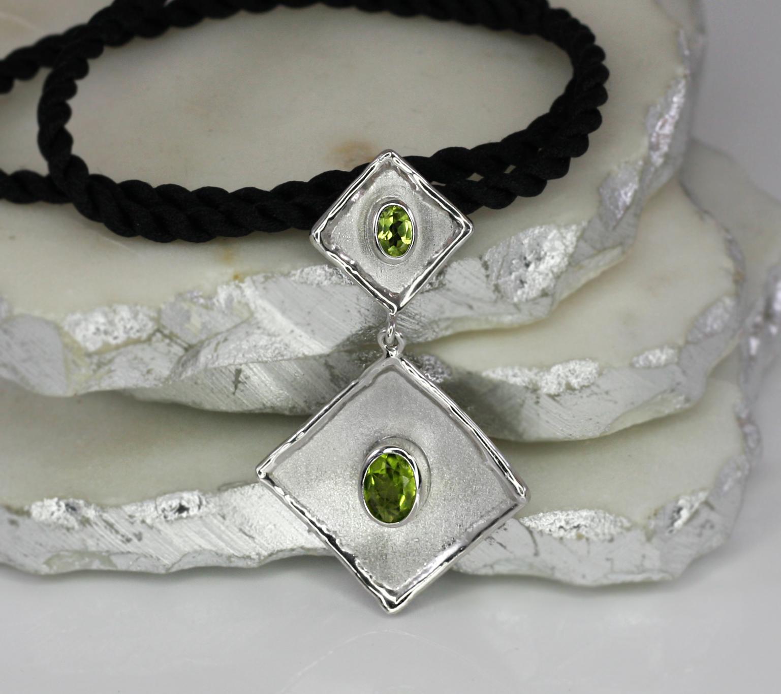 Yianni Creations fine silver 950 purity plated with palladium pendant necklace from Ammos Collection crafted in Greece and features 2.0 Carat oval cut Peridot. 
The gorgeous unique look of this enhancer is created by combining two techniques of