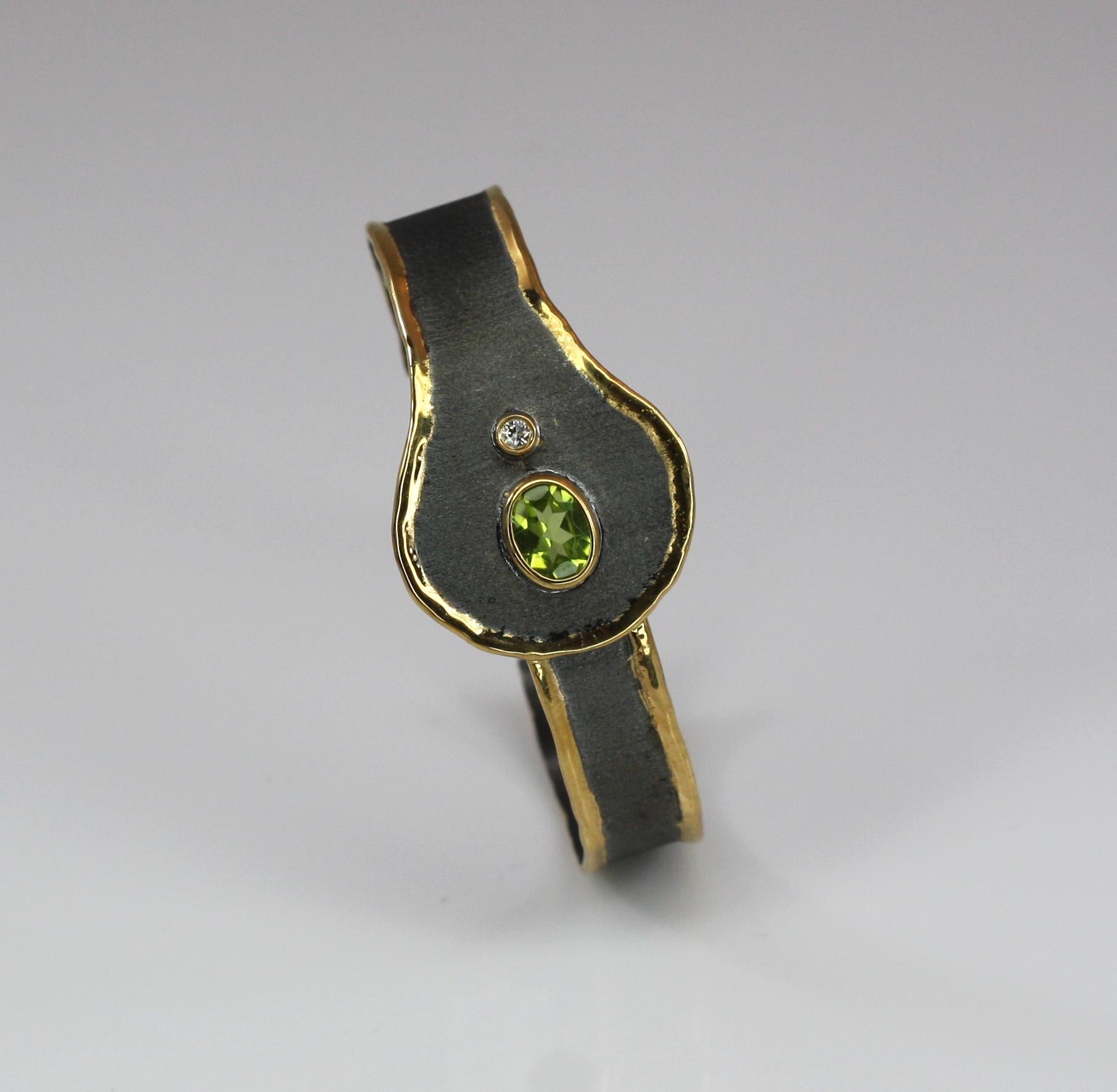 Il braccialetto artigianale in argento di Yianni Creations presenta un peridoto da 2,00 carati accompagnato da un diamante bianco da 0,07 carati a taglio brillante ed è realizzato a mano in argento 950 di elevata purezza. Il bracciale è rifinito con