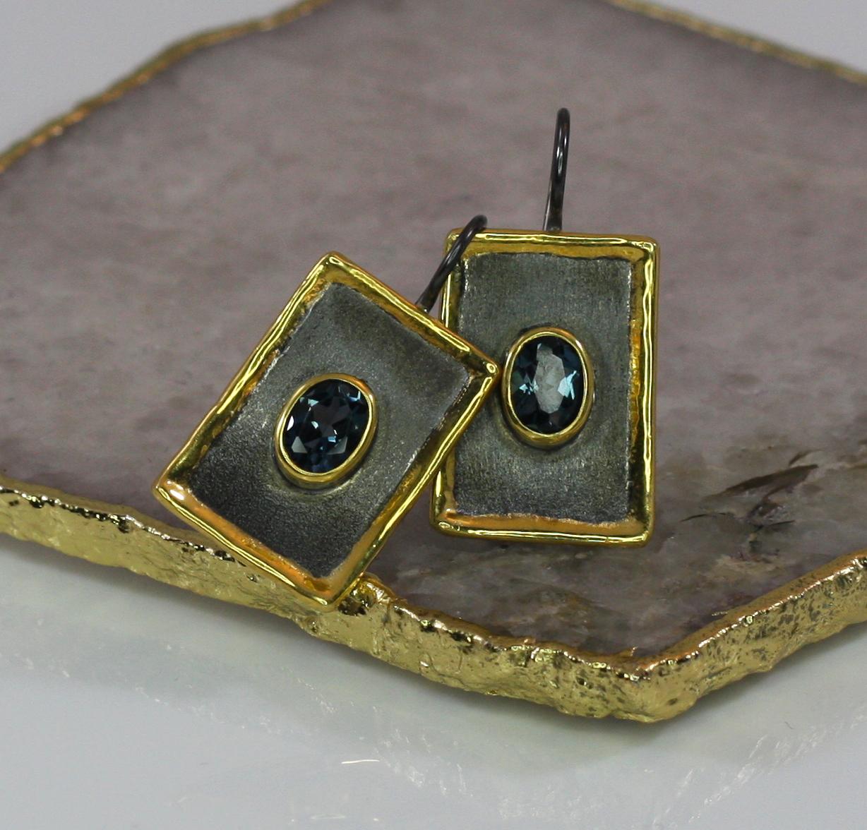 From the Yianni Creations Eclyps Collection, this is a handmade artisan pair of earrings made from fine silver 950 purity finished in Black Rhodium and 24 Karat Gold. Each earring features 1.60 Carat London Blue Topaz in an oval shape, making it