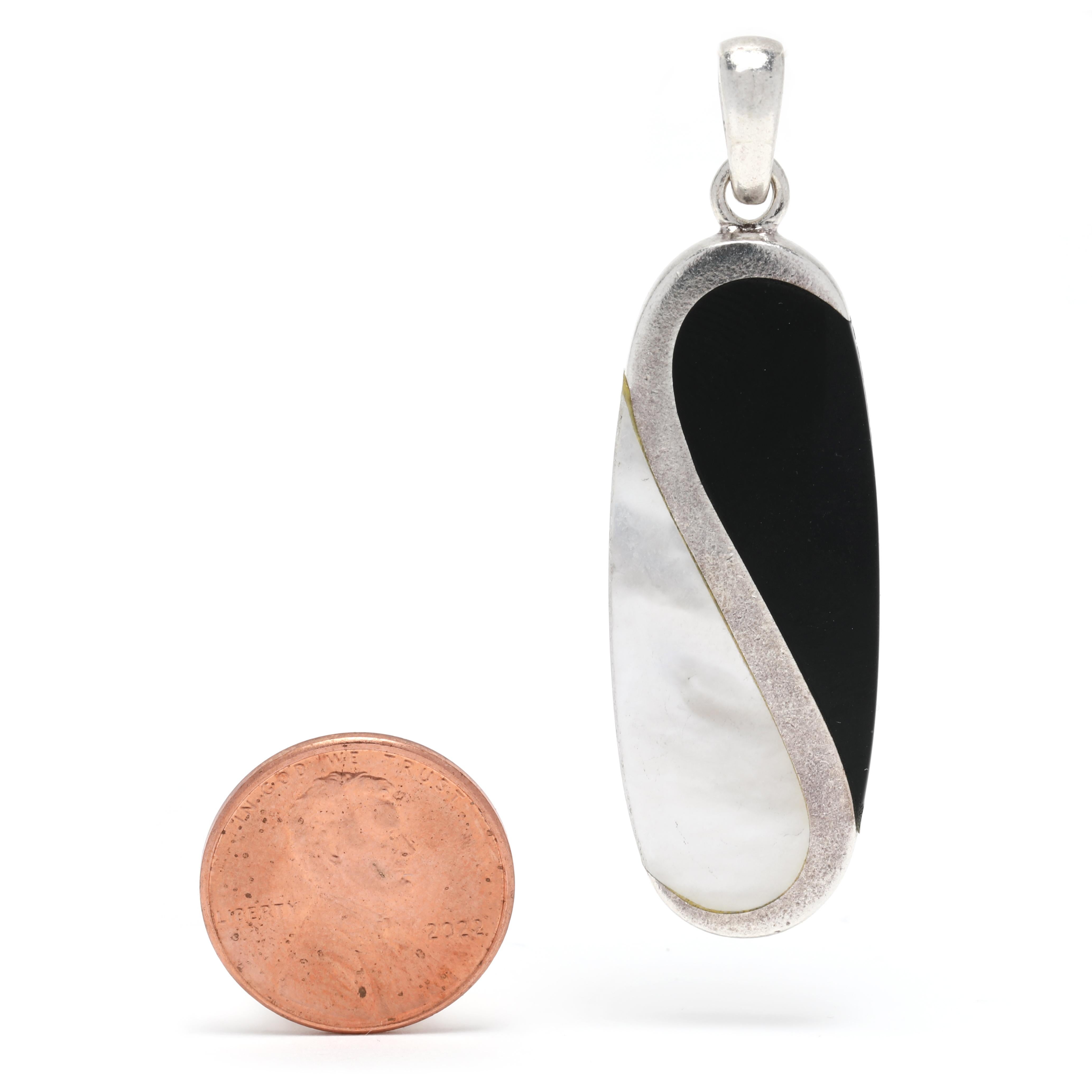 This Yin and Yang black onyx and mother of pearl long oval pendant is a perfect representation of the harmony and balance of opposites, in a beautiful and elegant design. Crafted from sterling silver, the pendant measures 2 1/8 inches in length,